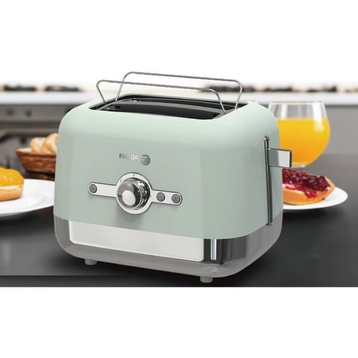 Ein mintgrüner Toaster mit Chromsockel, Toast mit Marmelade und ein Glas Orangensaft.