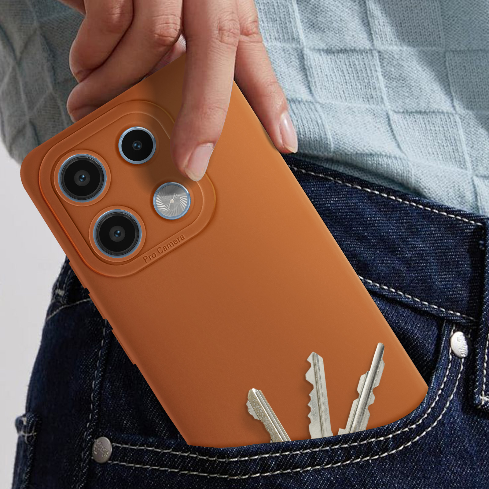 Telefono arancione con custodia in tasca di jeans, chiavi visibili. Dettaglio fotocamera.