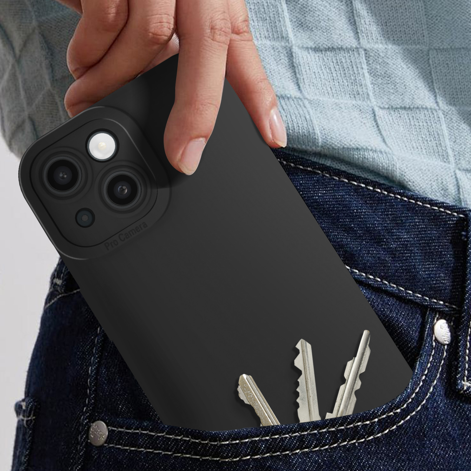 Mano sosteniendo un teléfono en una funda negra, llaves en el bolsillo.