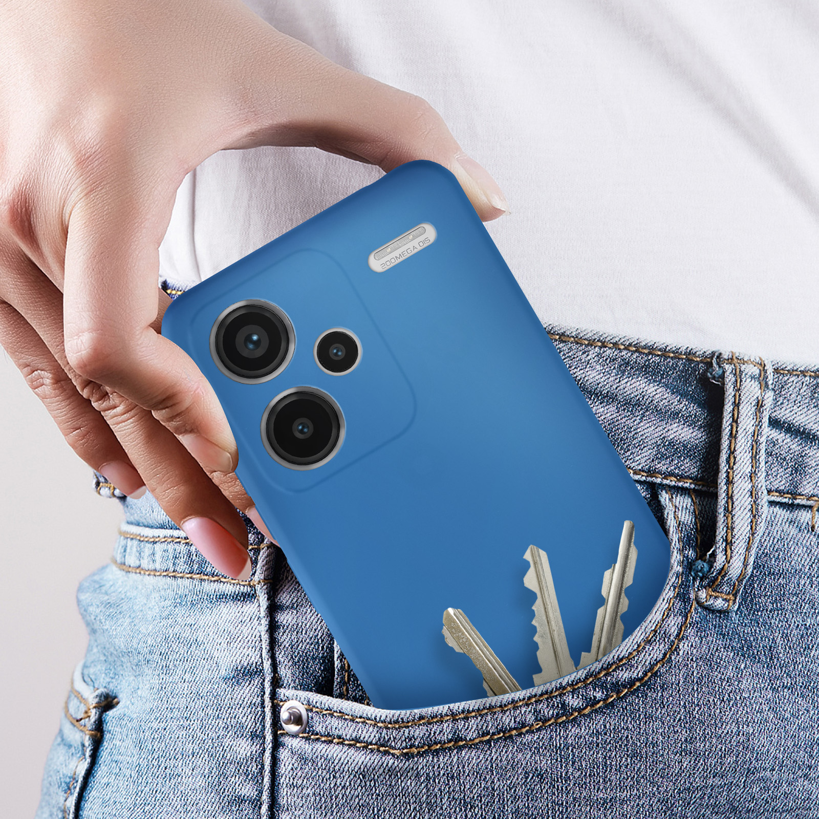 Mano che mette un telefono blu in tasca dei jeans con chiavi. Telefono con fotocamere e pulsanti visibili.