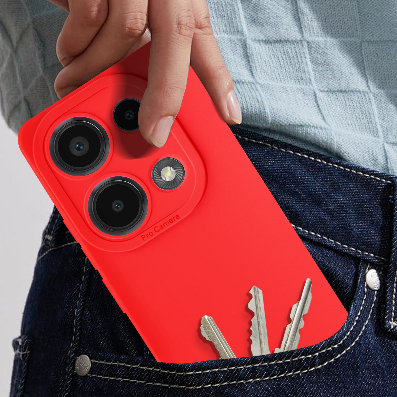 Telefono rosso nella tasca dei jeans con chiavi. La mano tiene il telefono con la pro camera. Chiavi visibili.