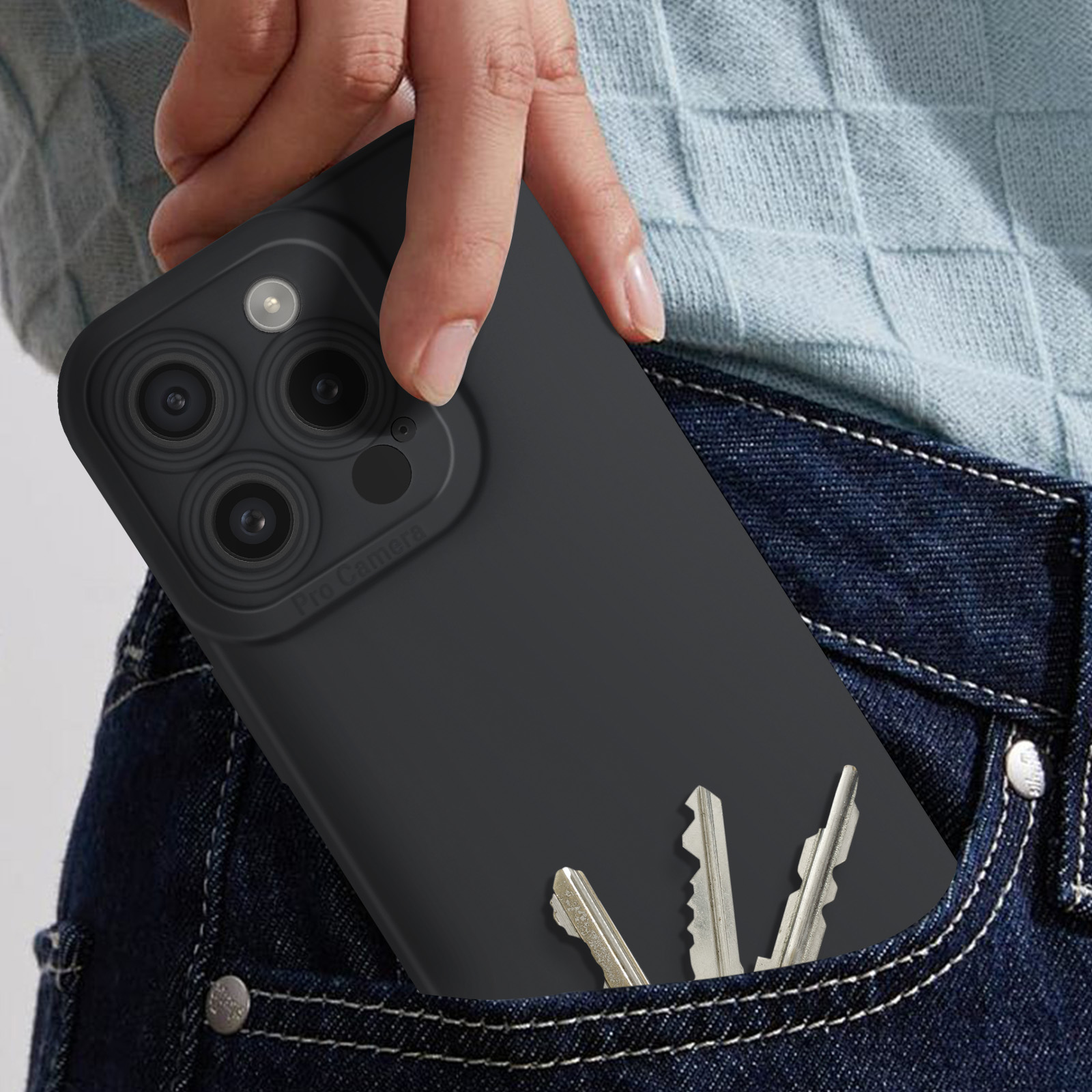 Mano in tasca che tiene una custodia nera per telefono con chiavi. Jeans blu scuro.