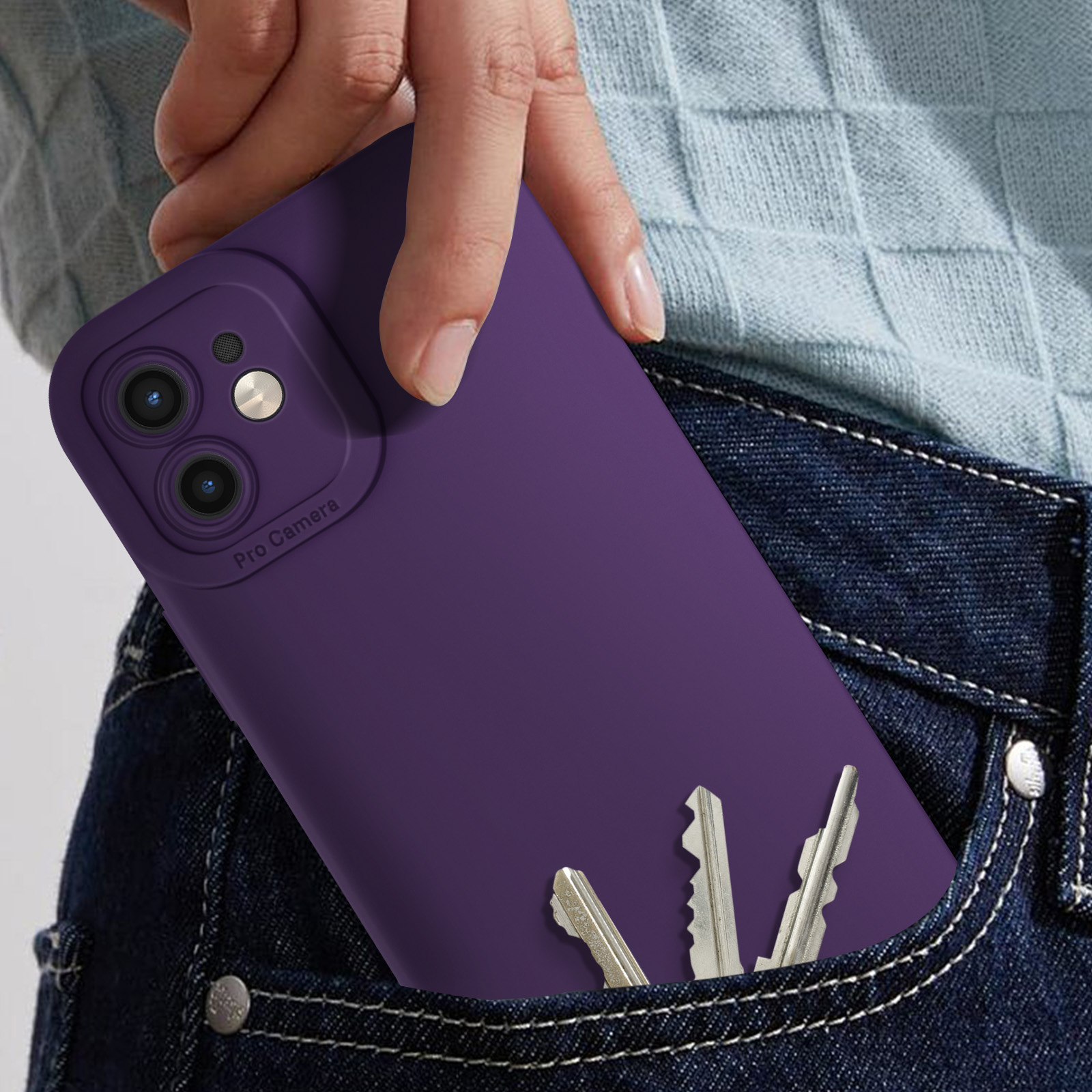 Mano che tiene un telefono viola in una tasca dei jeans, con tre chiavi.