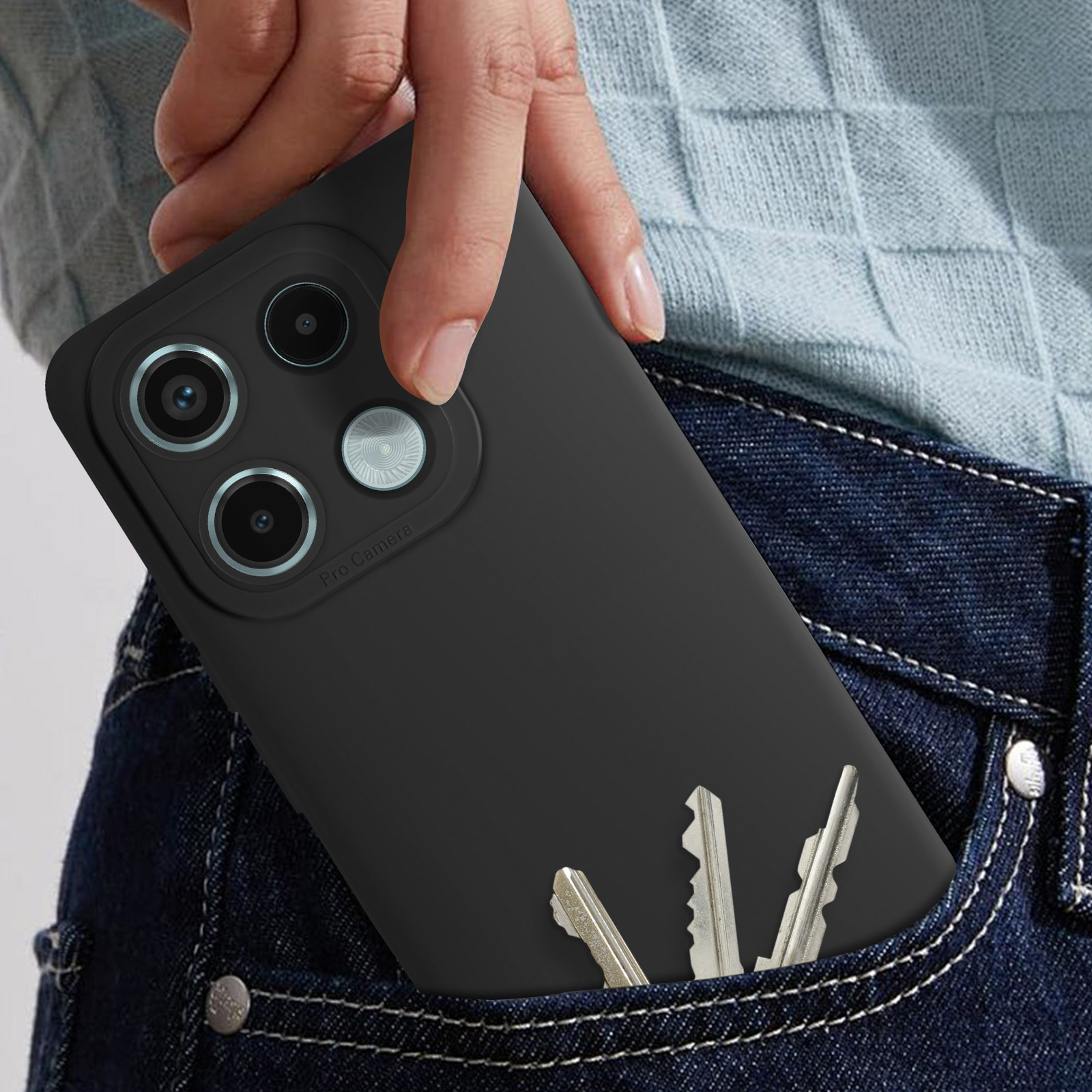 Mano che tiene un telefono nero in una tasca di jeans. Chiavi in tasca. Telefono con 3 fotocamere.