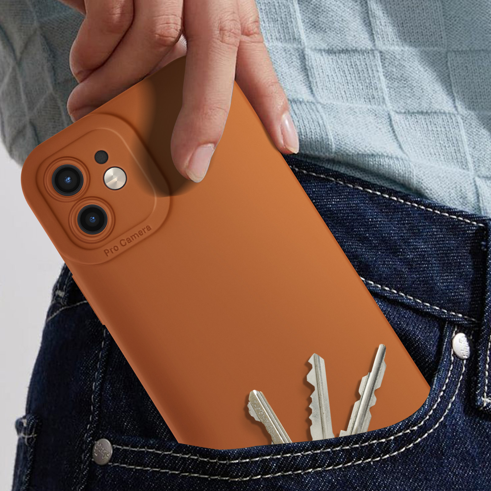 Mano in tasca di jeans con custodia per telefono e chiavi. Il telefono è arancione, le chiavi sono argentate.