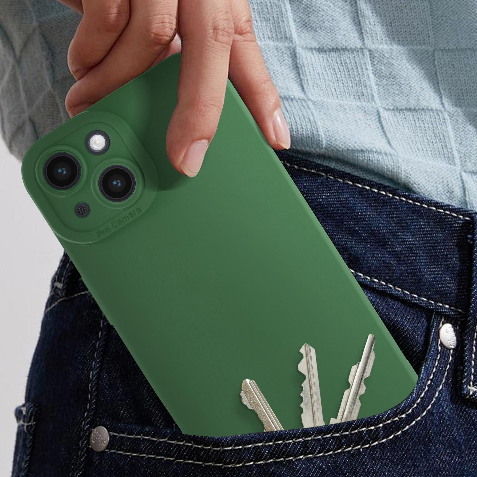 Mano che tiene un telefono verde in tasca di jeans, con chiavi.