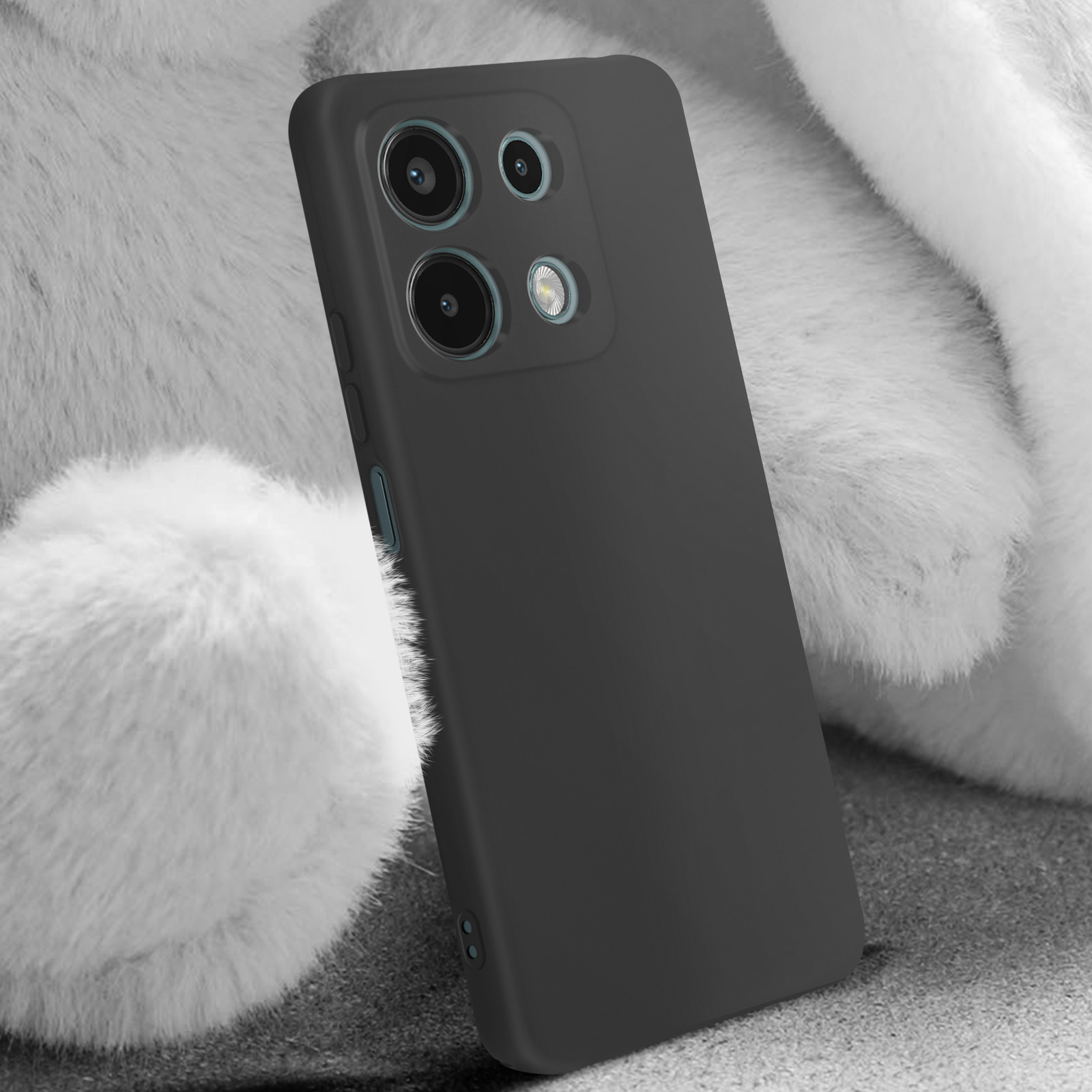 Una custodia per telefono nera con quattro fotocamere, davanti a una superficie bianca e soffice.