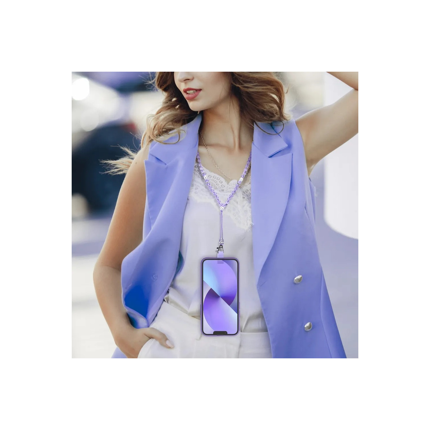 Una donna con un telefono con un cordino al collo. Indossa un gilet blu e una maglia bianca.