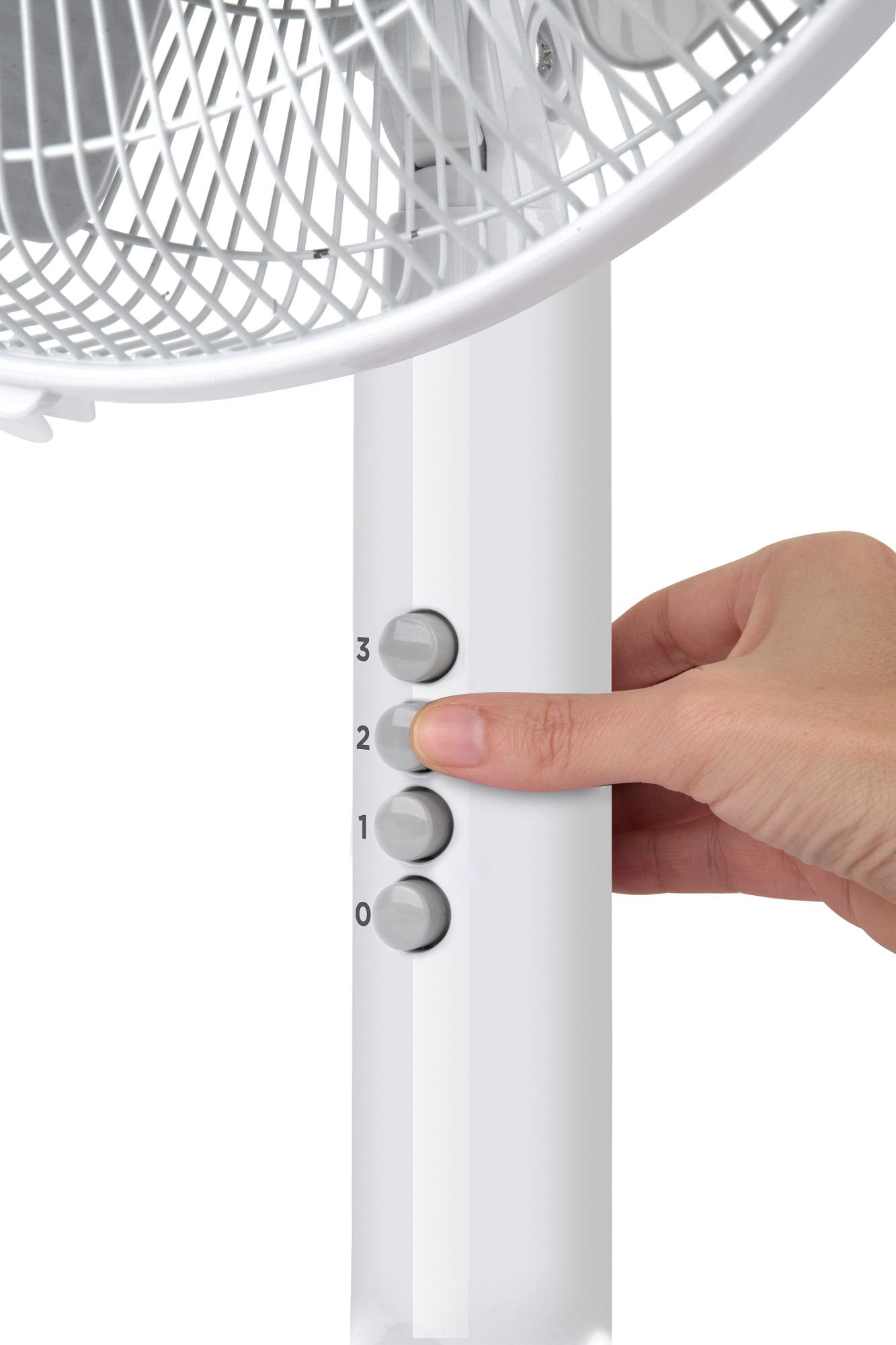 Ręka naciskająca przycisk prędkości wentylatora na białym wentylatorze stojącym.