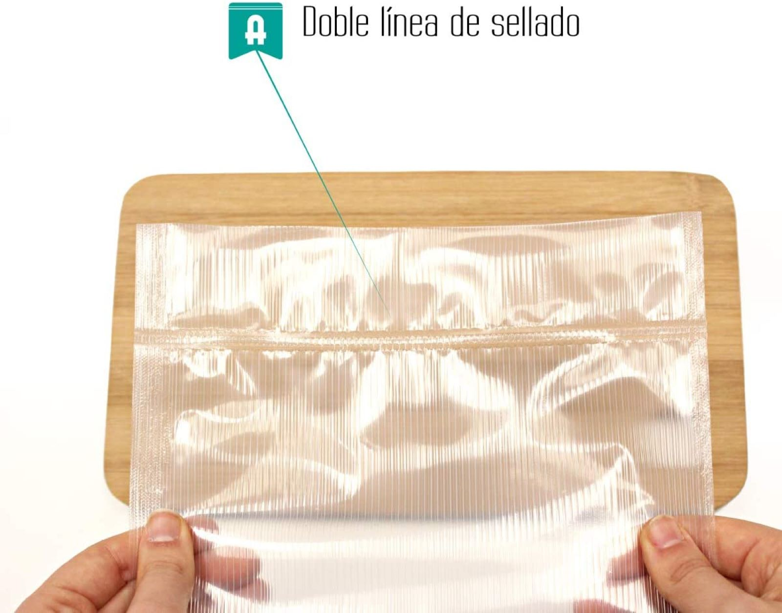 Manos sosteniendo una bolsa de plástico transparente sobre una tabla de madera. La bolsa tiene doble sellado.