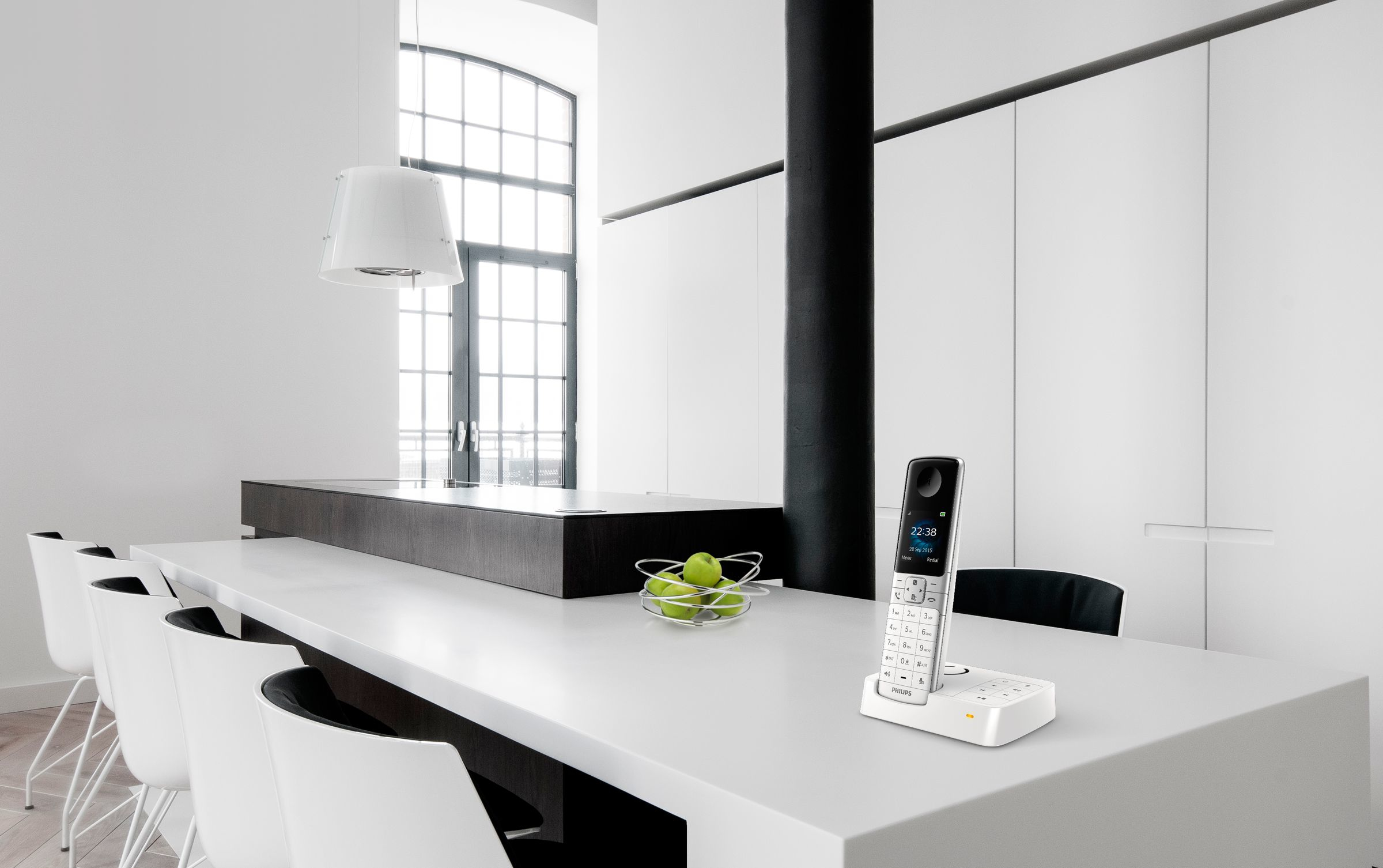 Cuisine moderne avec un téléphone sur un plan de travail blanc. Table et chaises blanches.