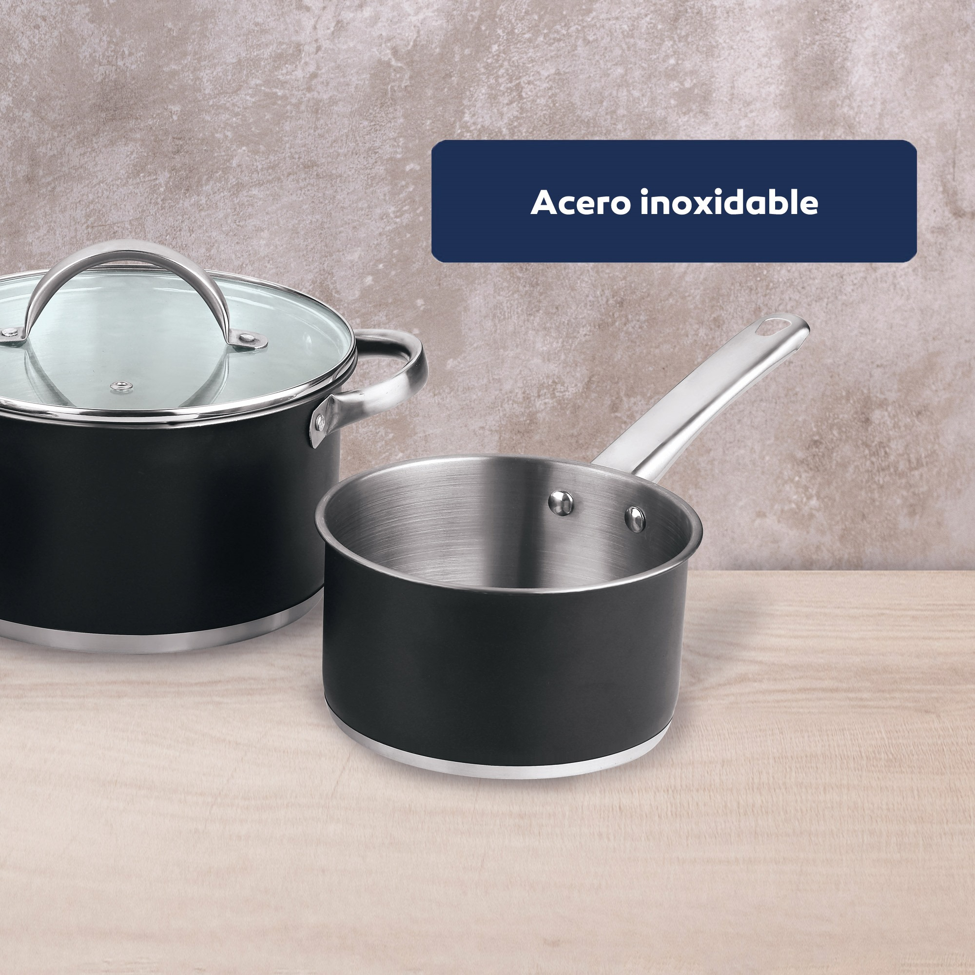 Dos ollas de acero inoxidable sobre madera. Una con tapa, otra con asa.
