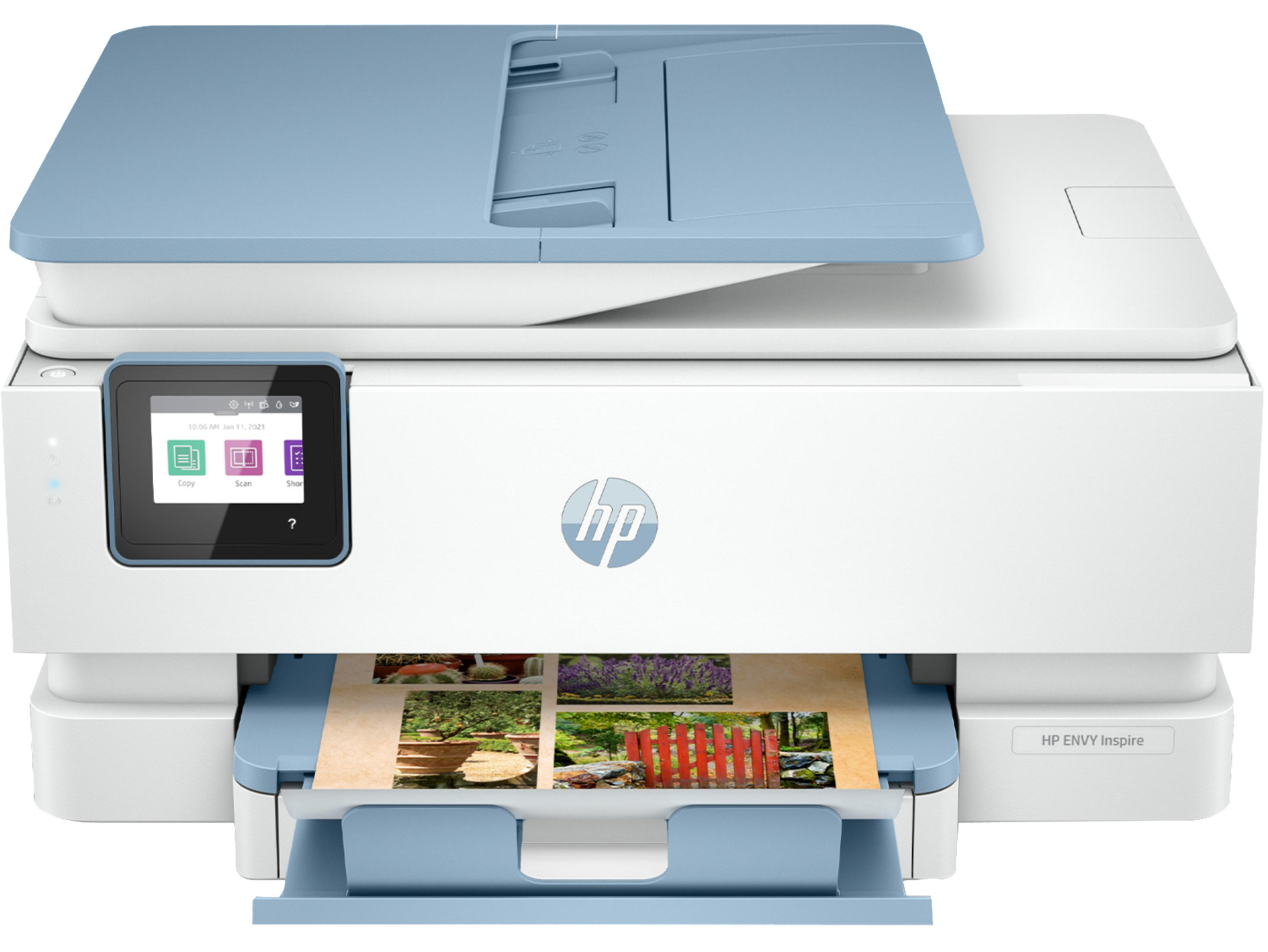 Impresora HP Envy Inspire blanca con tapa y bandeja de papel azul claro, mostrando una foto impresa.