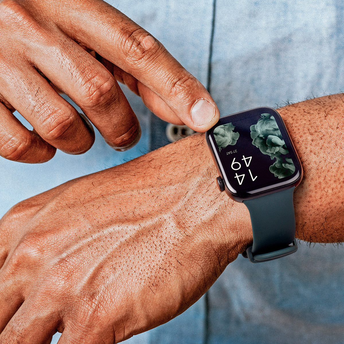 Il polso di una persona con uno smartwatch. Il quadrante mostra un motivo floreale e l'ora.