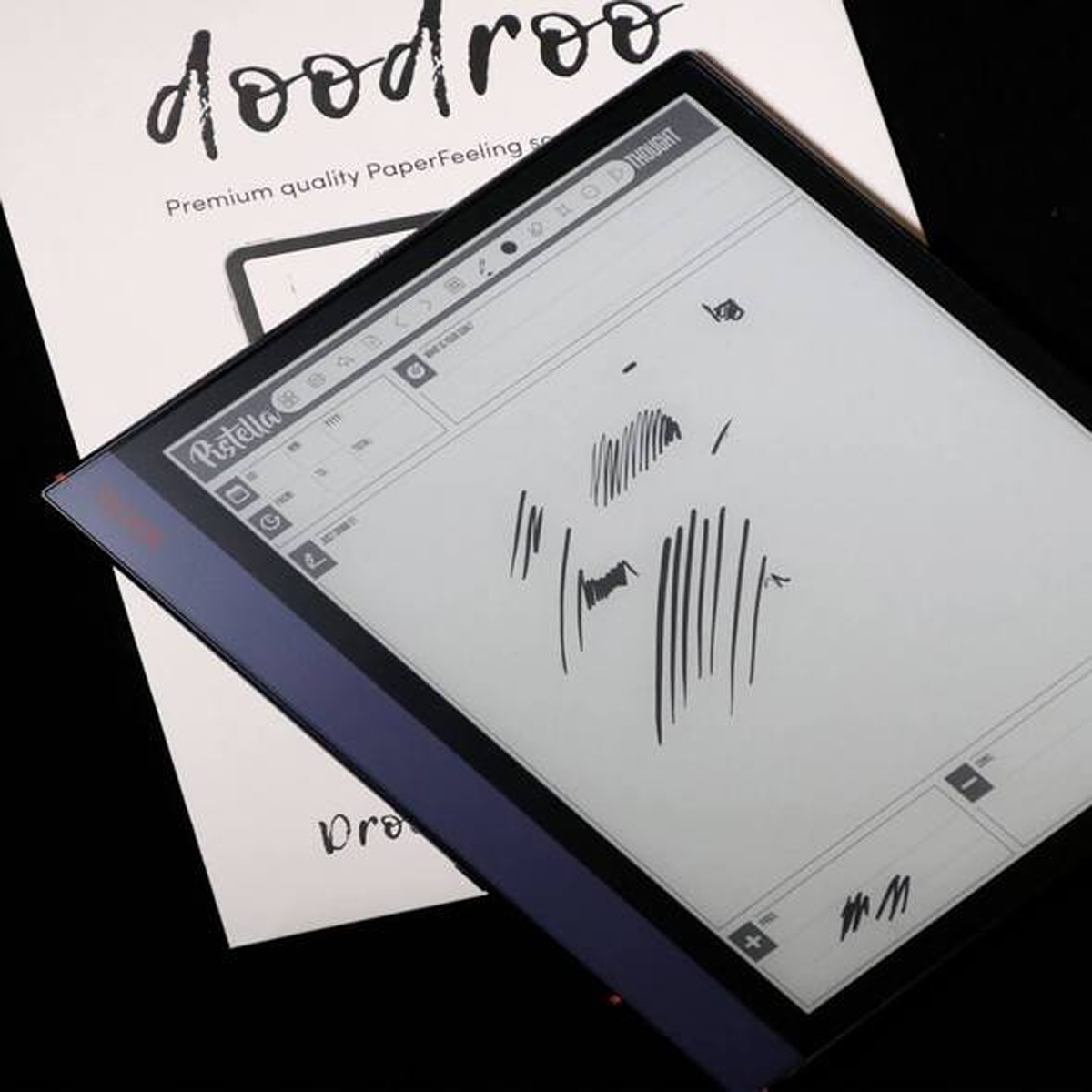 Tableta con un lápiz y dibujo en la pantalla, con un libro debajo. Blanco y negro.