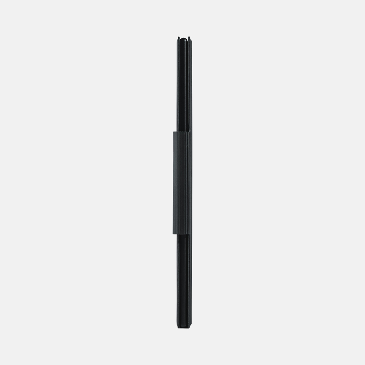Cartera negra, cerrada, de pie sobre una superficie blanca. Diseño minimalista.