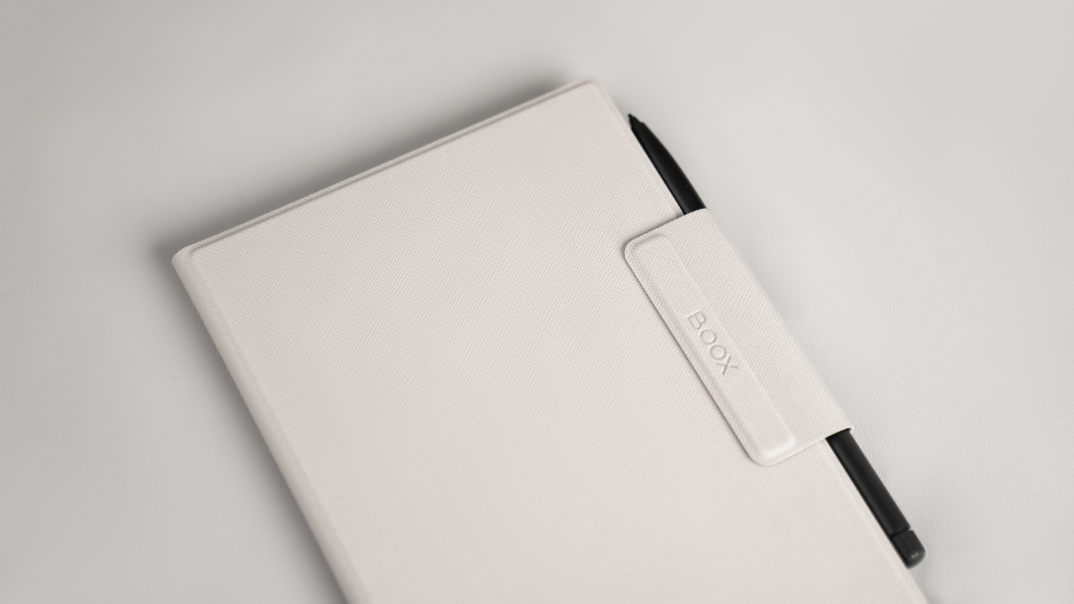 Un tablet bianco con stilo nero, un portapenne, su sfondo bianco.