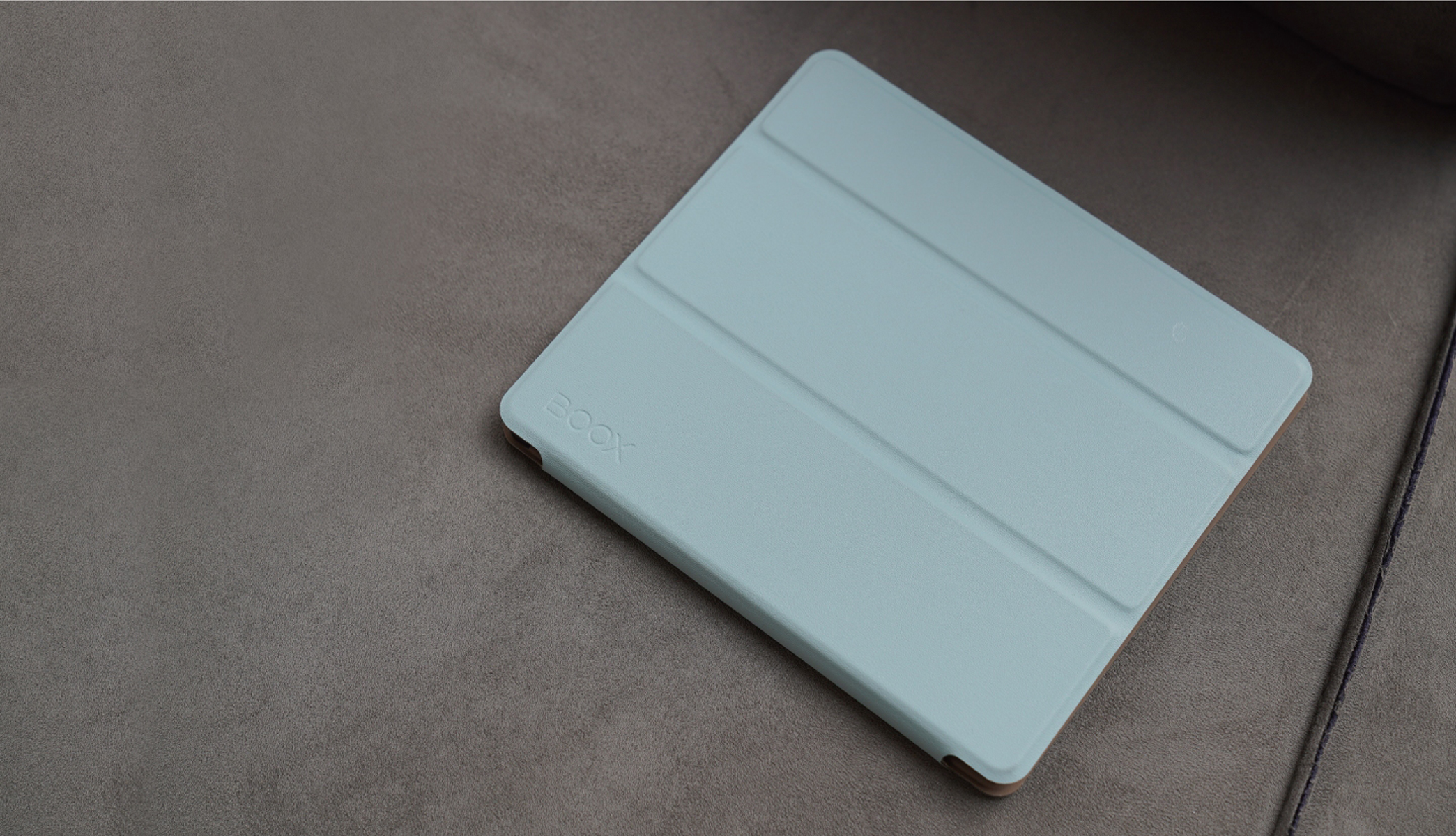 Eine hellblaue Tablet-Hülle mit dem BOOX-Logo liegt auf einer grauen Oberfläche. Die Hülle ist geschlossen.