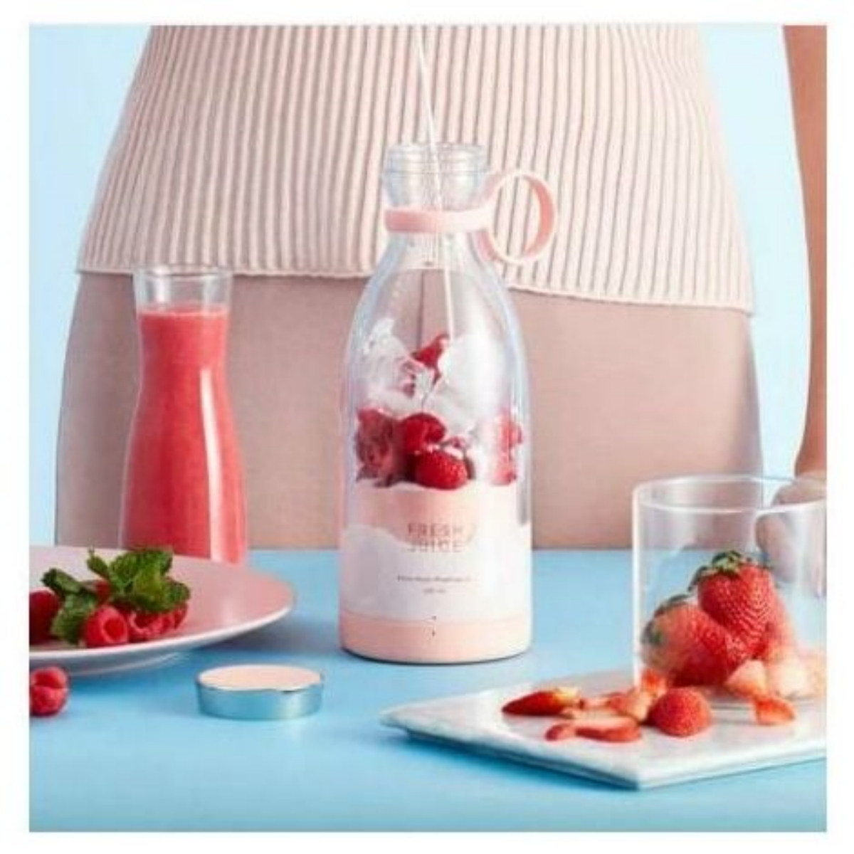 Mixer mit Erdbeeren, Himbeeren und Eis. Rosa Teller mit Beeren.
