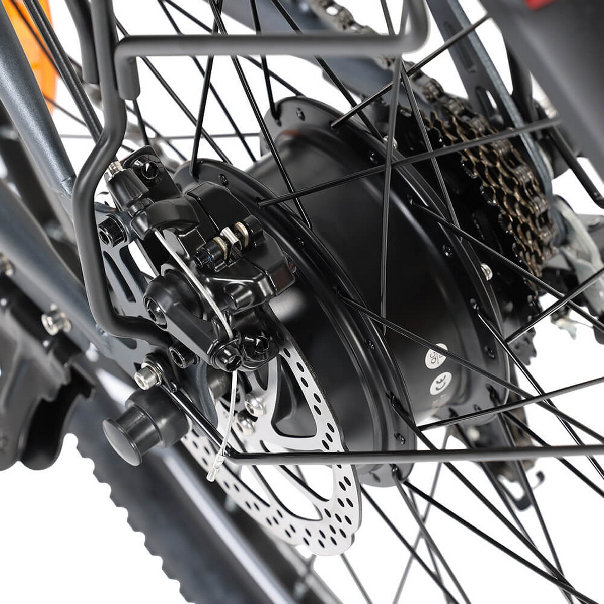 Zbliżenie koła rowerowego z hamulcami tarczowymi, biegami i szprychami.