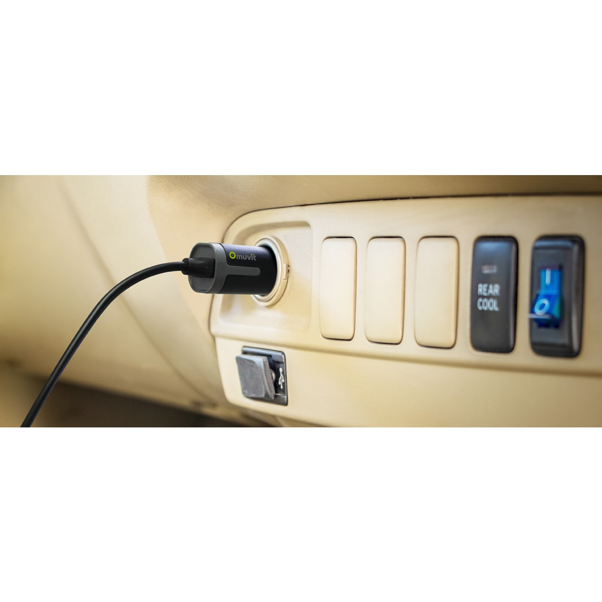 Interior del coche con un cargador enchufado y botones para funciones.