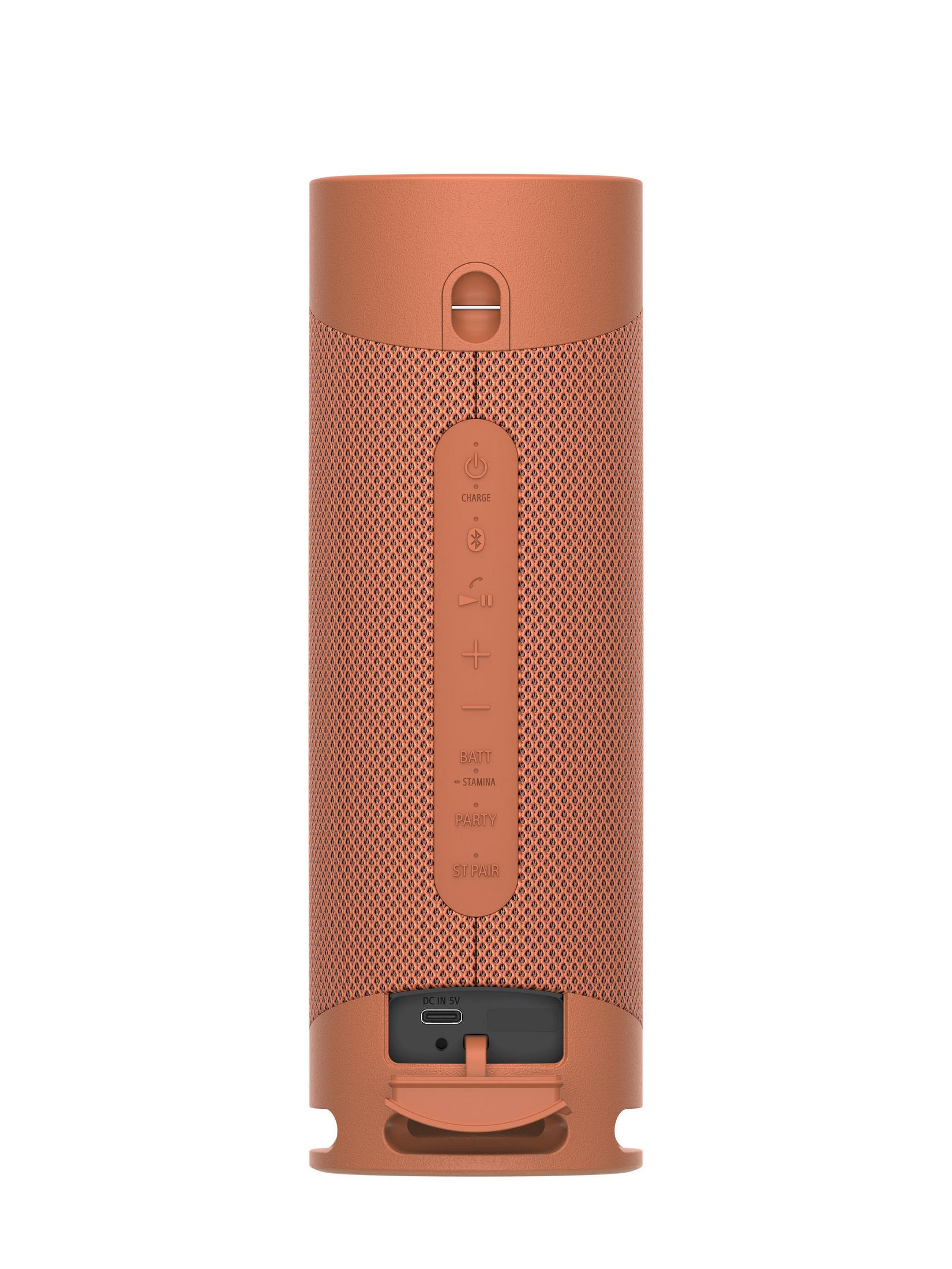 Orangener zylindrischer Lautsprecher mit Knöpfen und USB-Anschluss, auf weißem Hintergrund.
