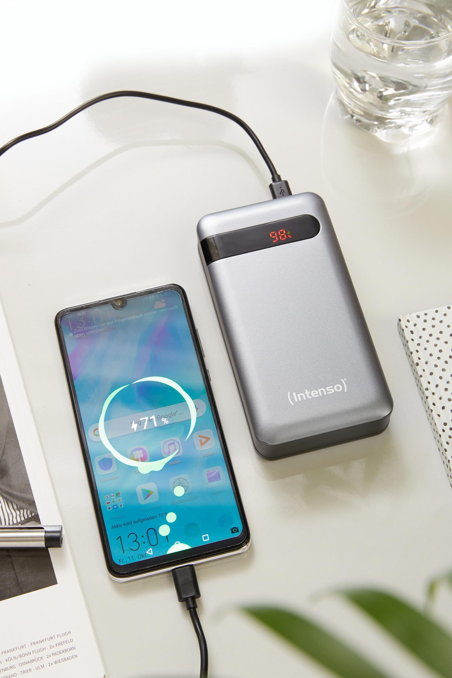 Een smartphone die wordt opgeladen vanaf een zilveren powerbank. De telefoon toont de oplaadvoortgang.