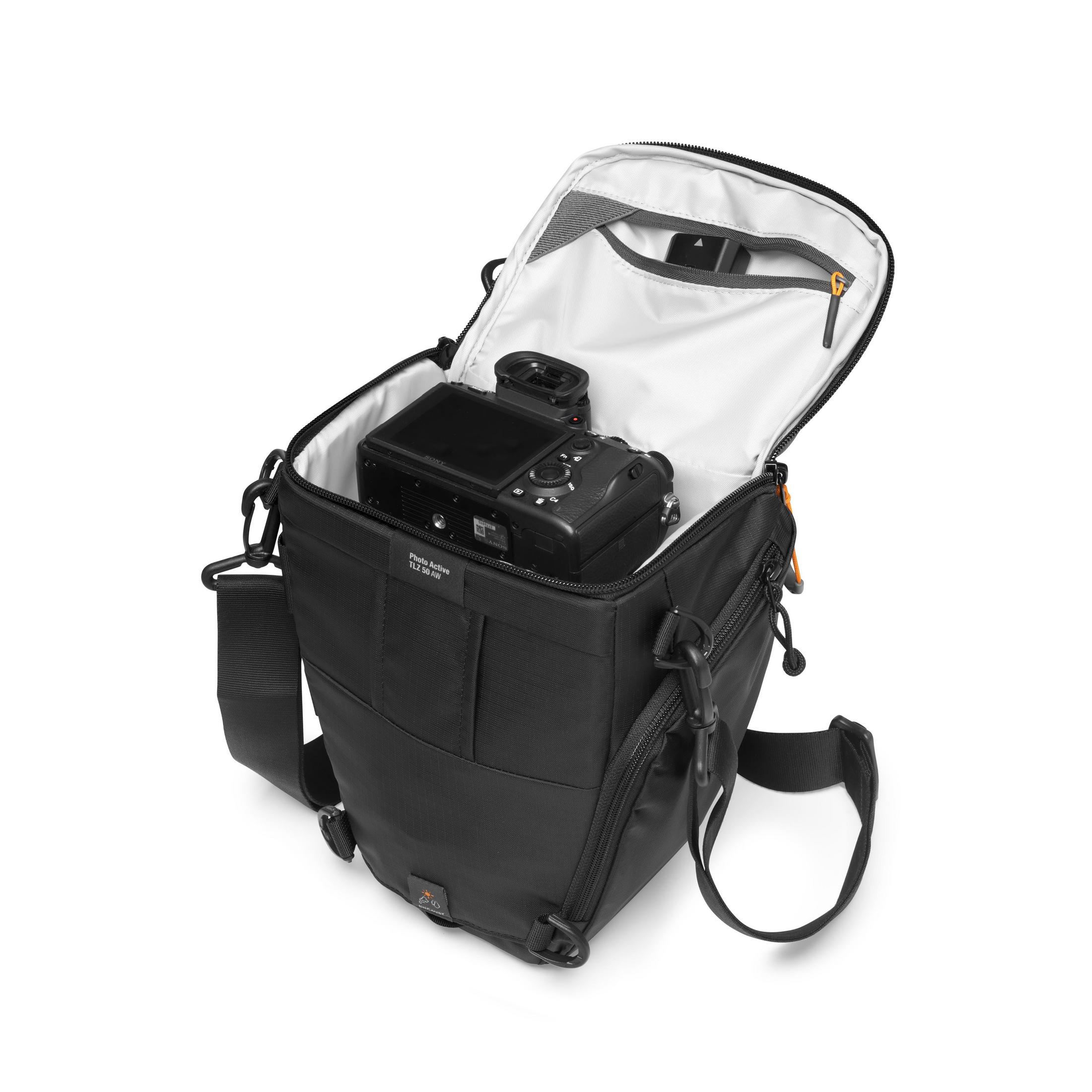 Un sac photo noir avec appareil photo à l'intérieur, ouvert et vu d'en haut.