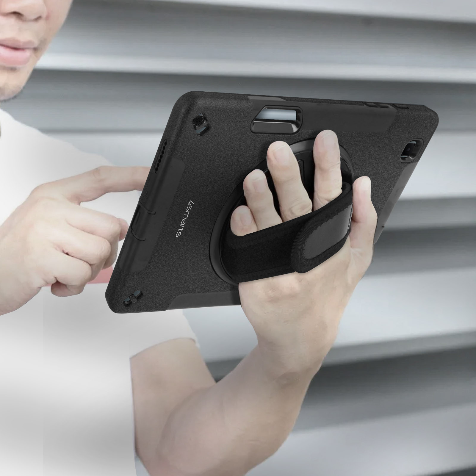 Eine Person hält ein schwarzes Tablet mit einer Handschlaufe auf der Rückseite.
