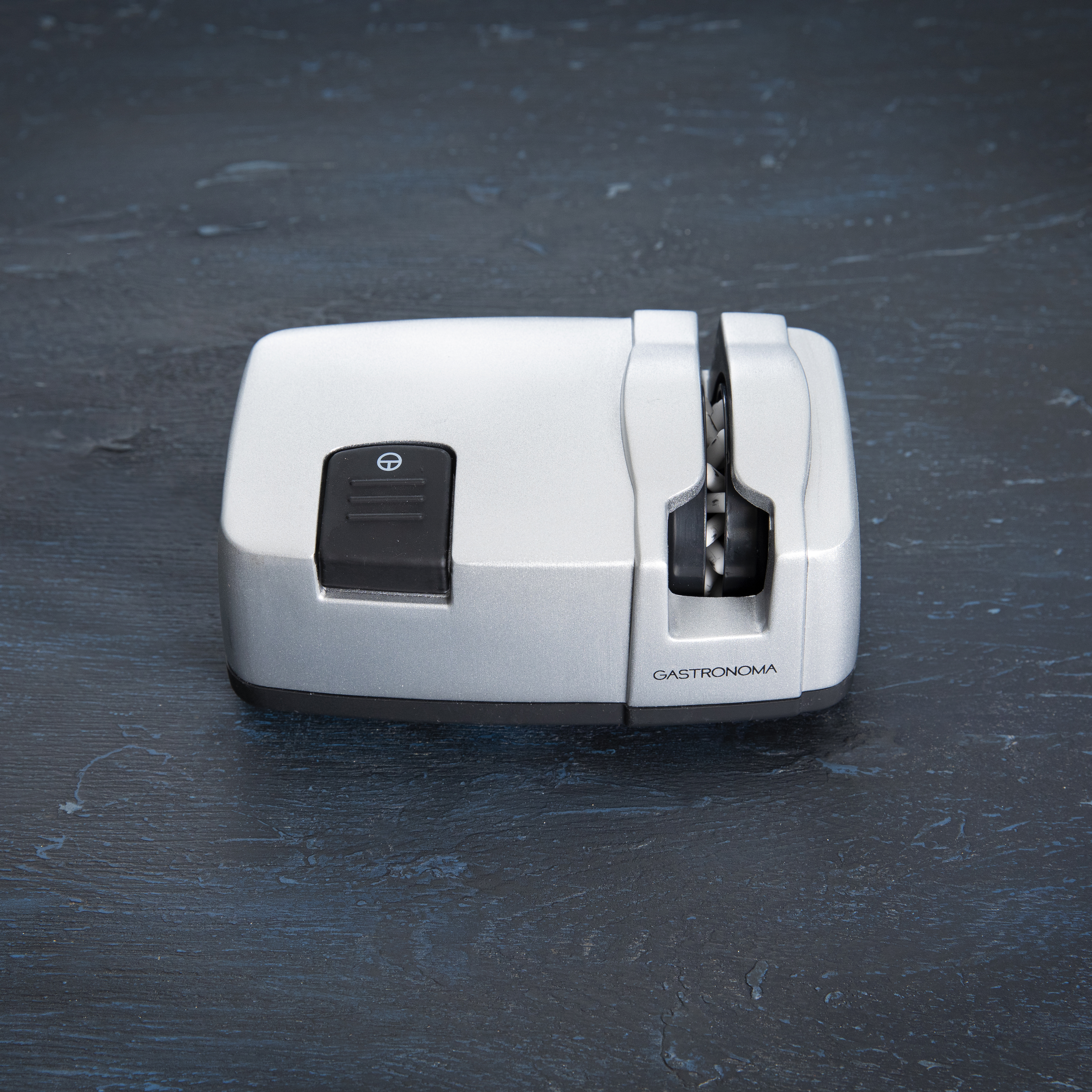 Srebrna ostrzałka do noży z czarnym przyciskiem i napisem 'GASTRONOMA'.