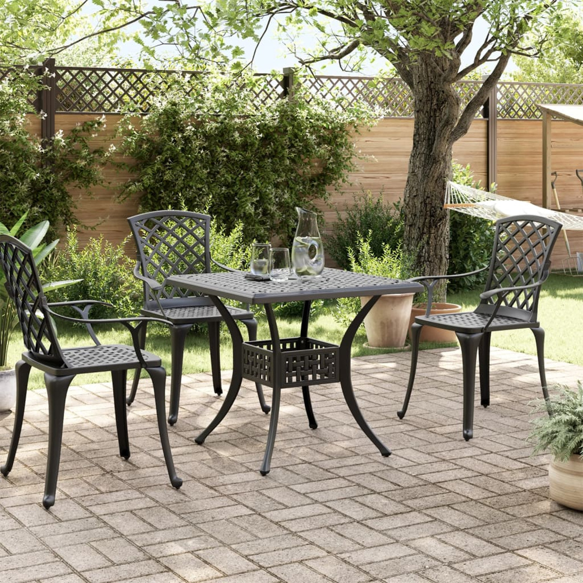 Essgruppe im Freien mit Tisch und Stühlen. Eine Gartenszene mit Bäumen und Pflanzen.