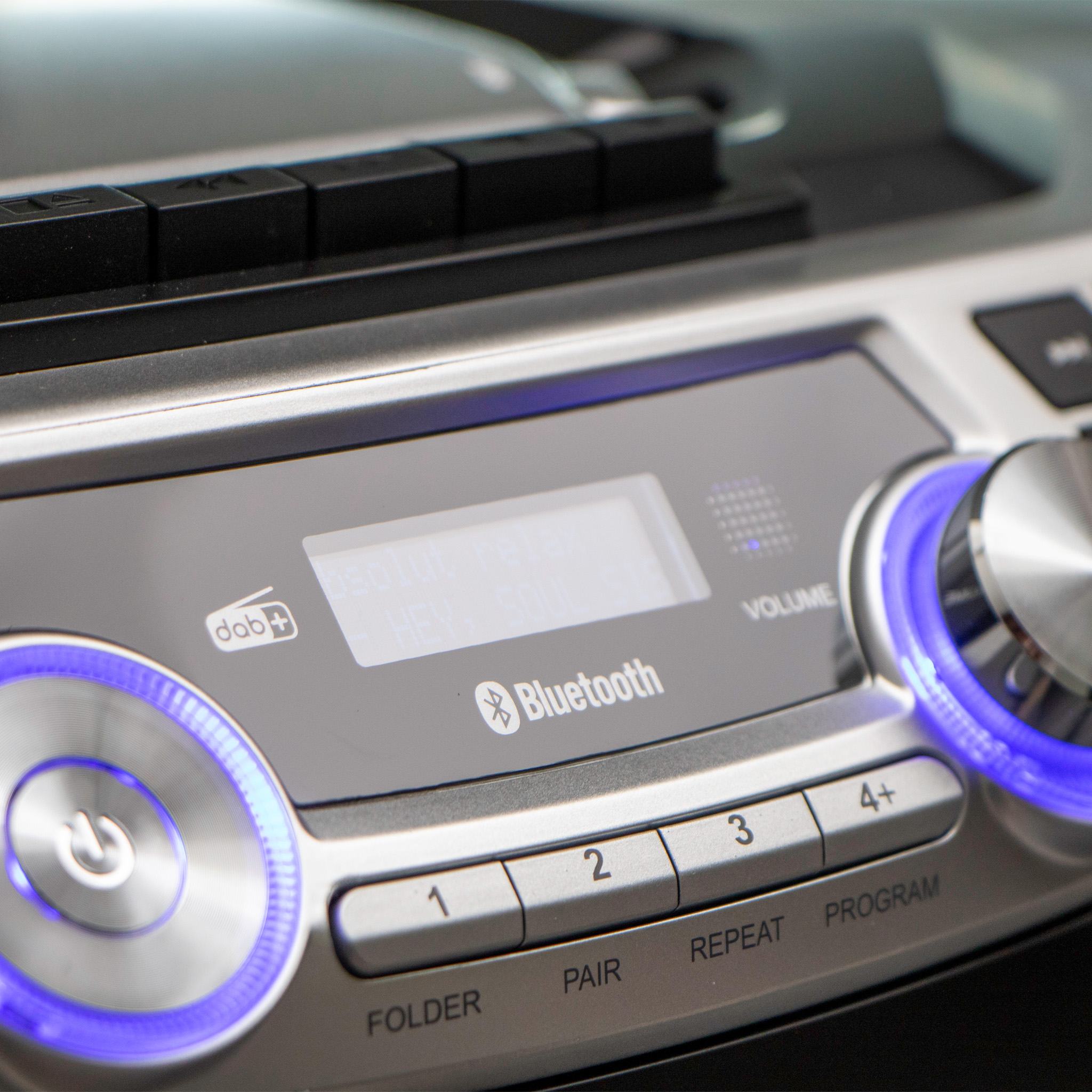 Chaîne stéréo argentée avec boutons, Bluetooth et écran éclairé. Boutons sont étiquetés.