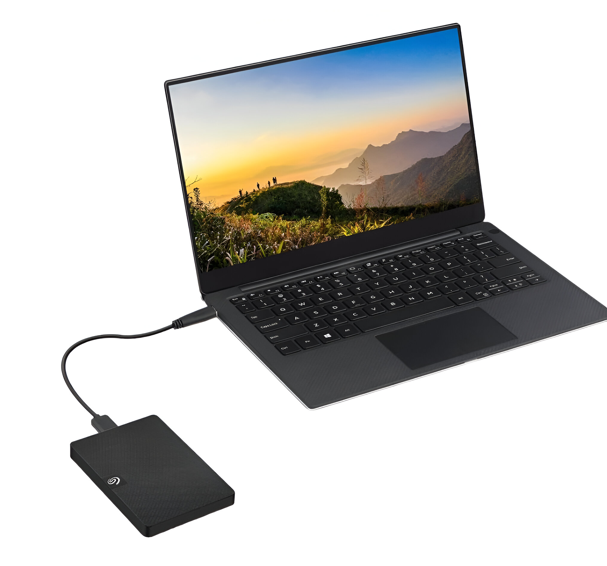 Una computadora portátil negra conectada a un disco duro externo negro. La pantalla muestra un paisaje montañoso.