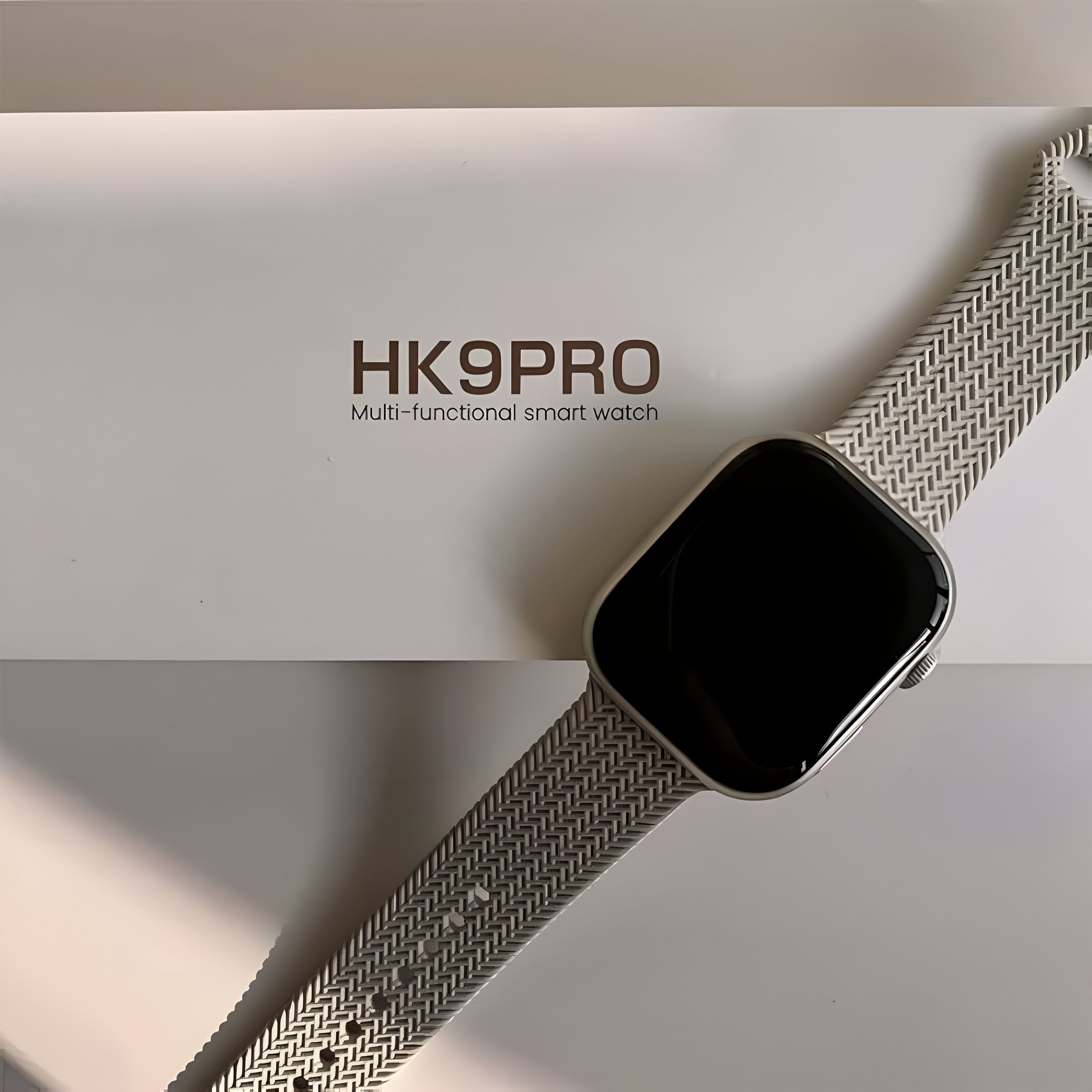 Reloj inteligente HK9PRO sobre un fondo blanco con texto. Un reloj rectangular con pantalla negra.