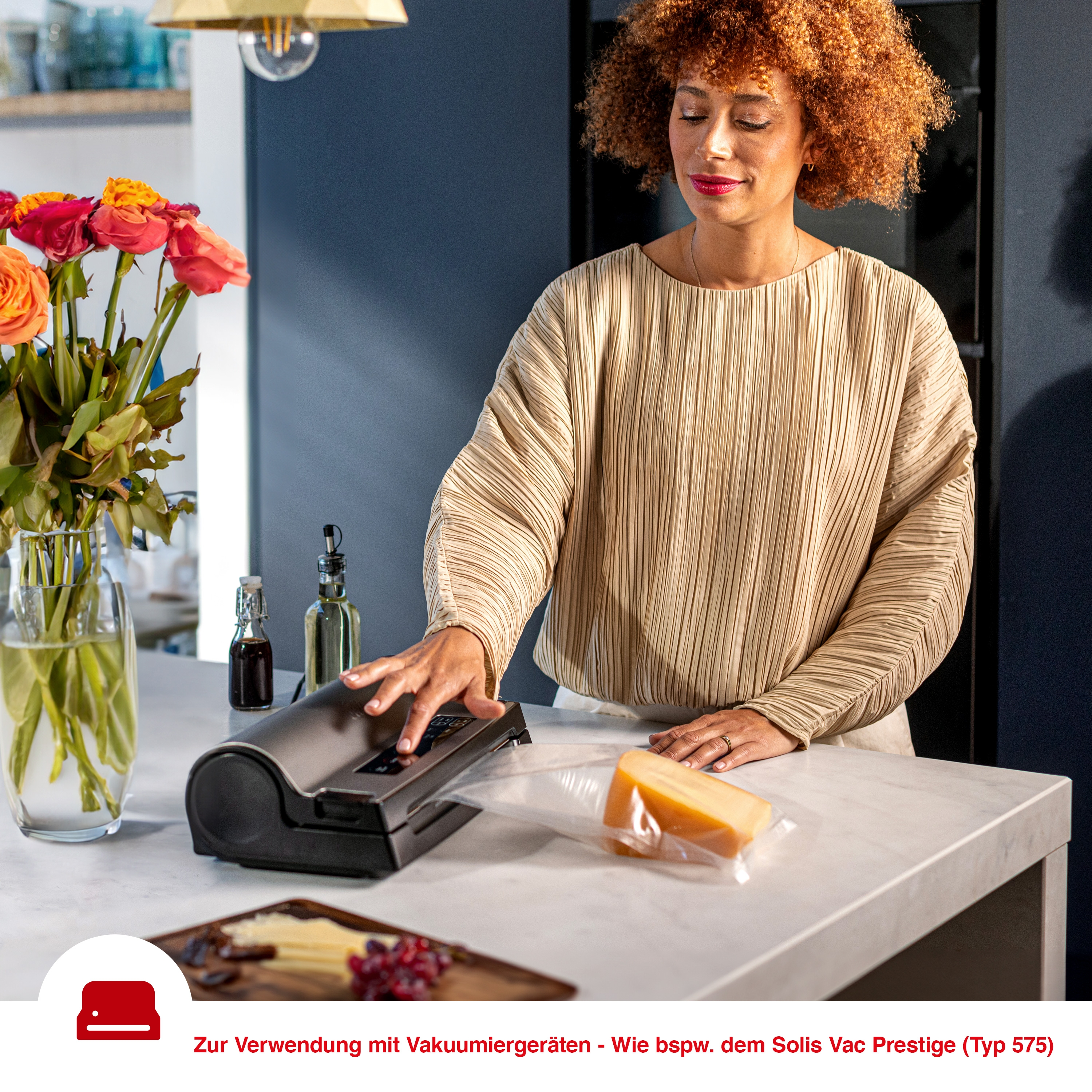 Frau benutzt Vakuumiergerät. Käse und Blumen sind sichtbar.