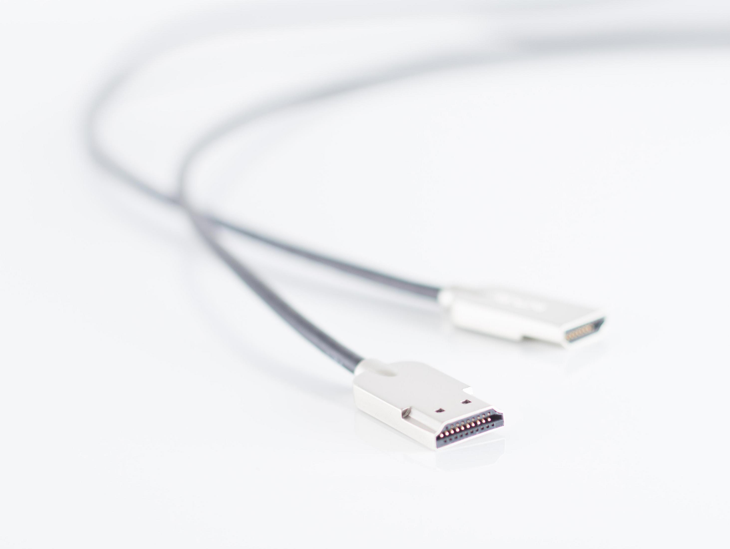 Zwei schwarze USB-Kabel mit silbernen Steckern. Die Kabel liegen auf weißem Untergrund.
