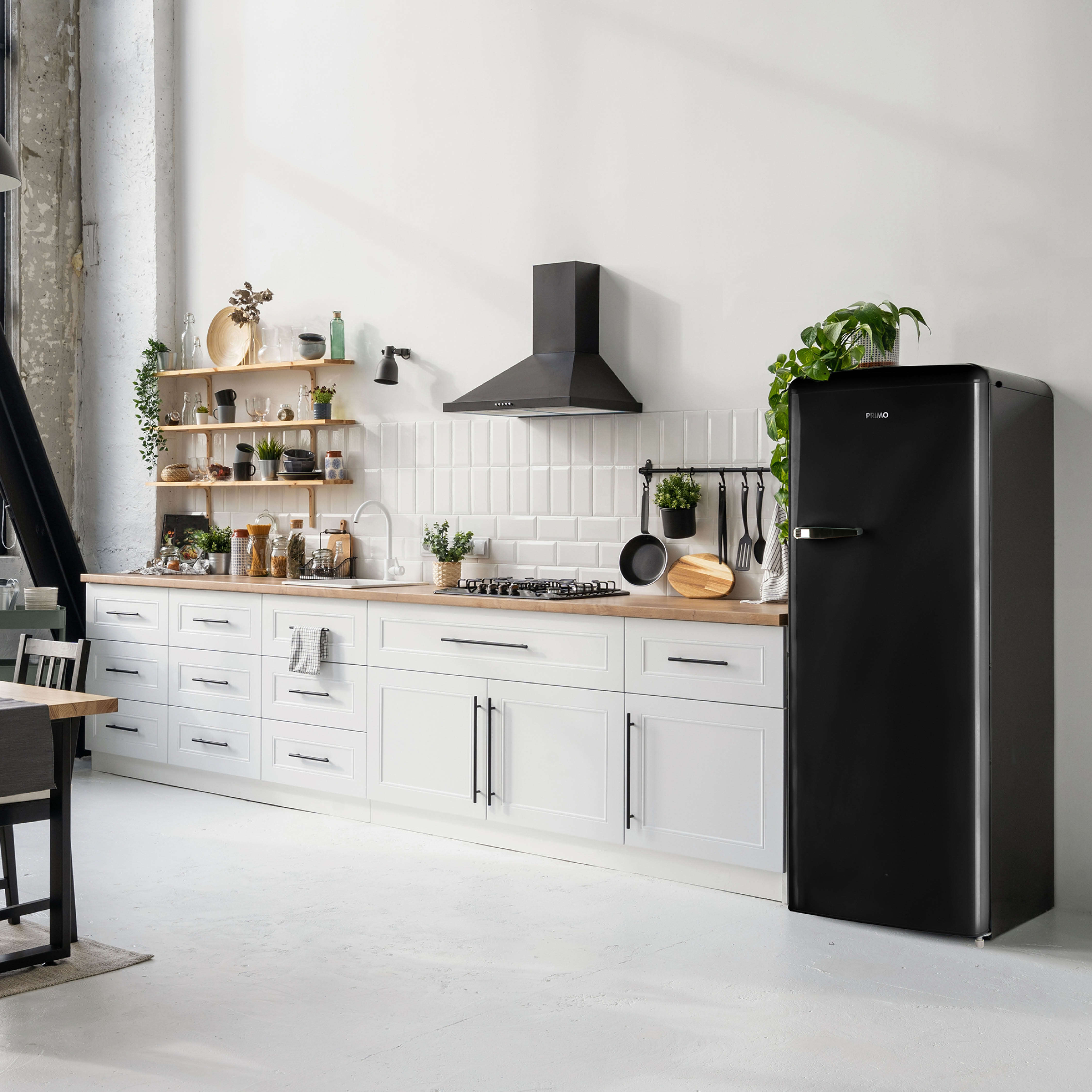Modern kitchen with white cabinets, wooden counters, black appliances, and a white floor.