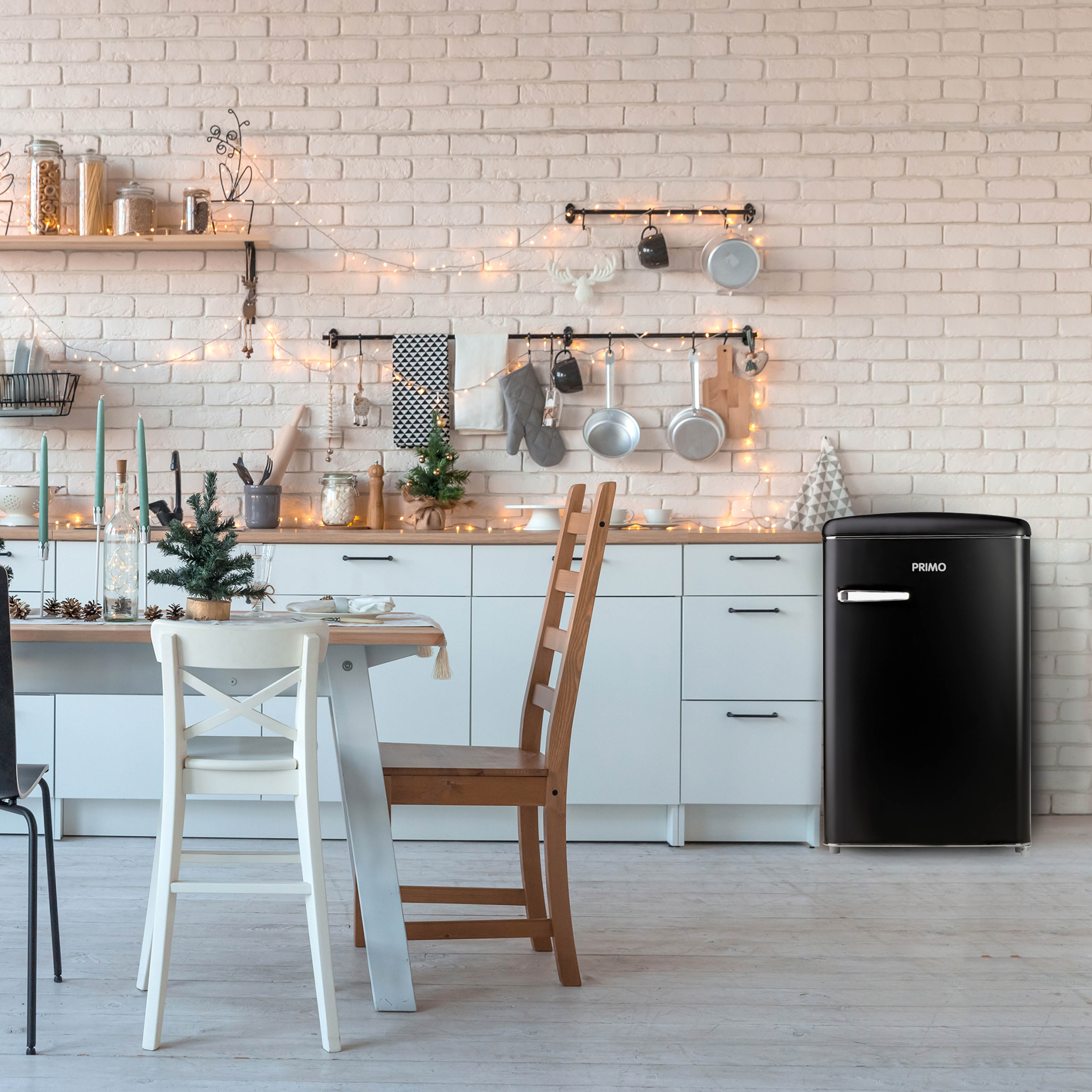 Scène de cuisine avec un réfrigérateur. Une table, des chaises et des éléments décoratifs sont présents.