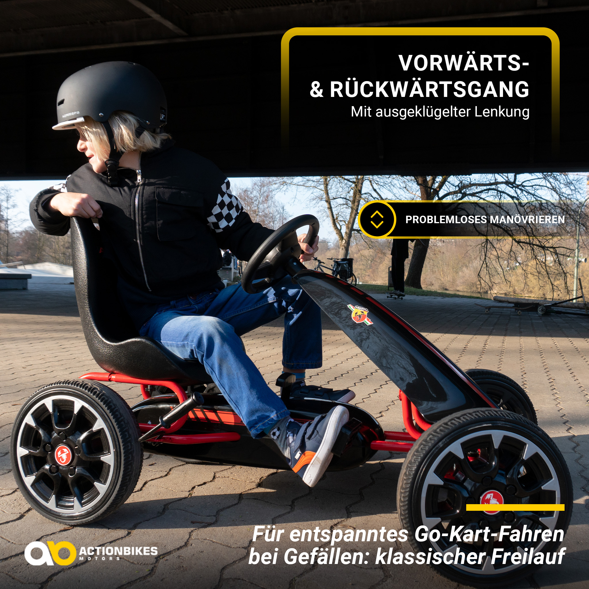 Ein Kind auf einem roten Go-Kart. Der Text lautet Vorwärts- und Rückwärtsgang mit einfachem Manövrieren.
