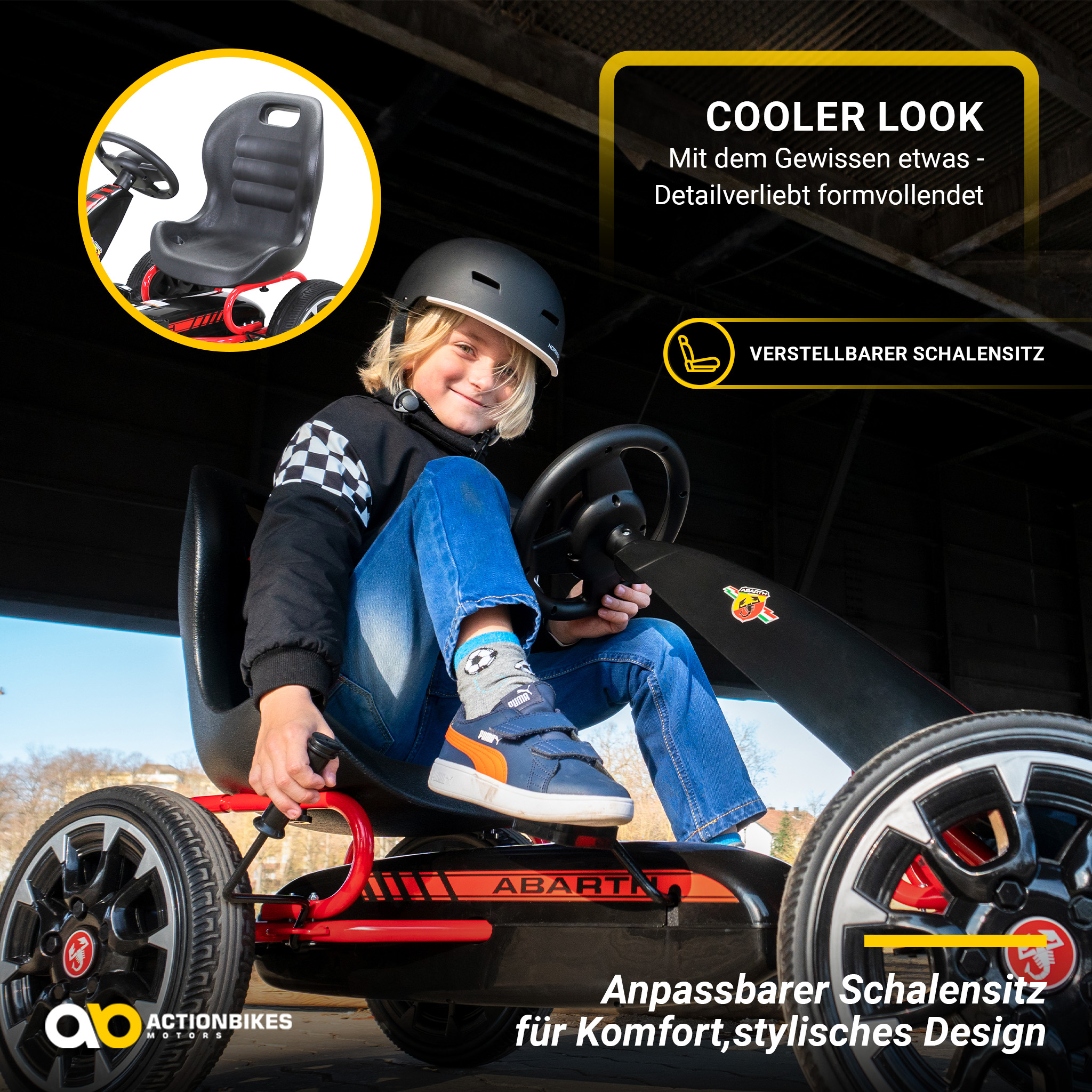 Ein Junge mit Helm sitzt in einem schwarz-roten Go-Kart, lächelt. Schwarzer Hintergrund.