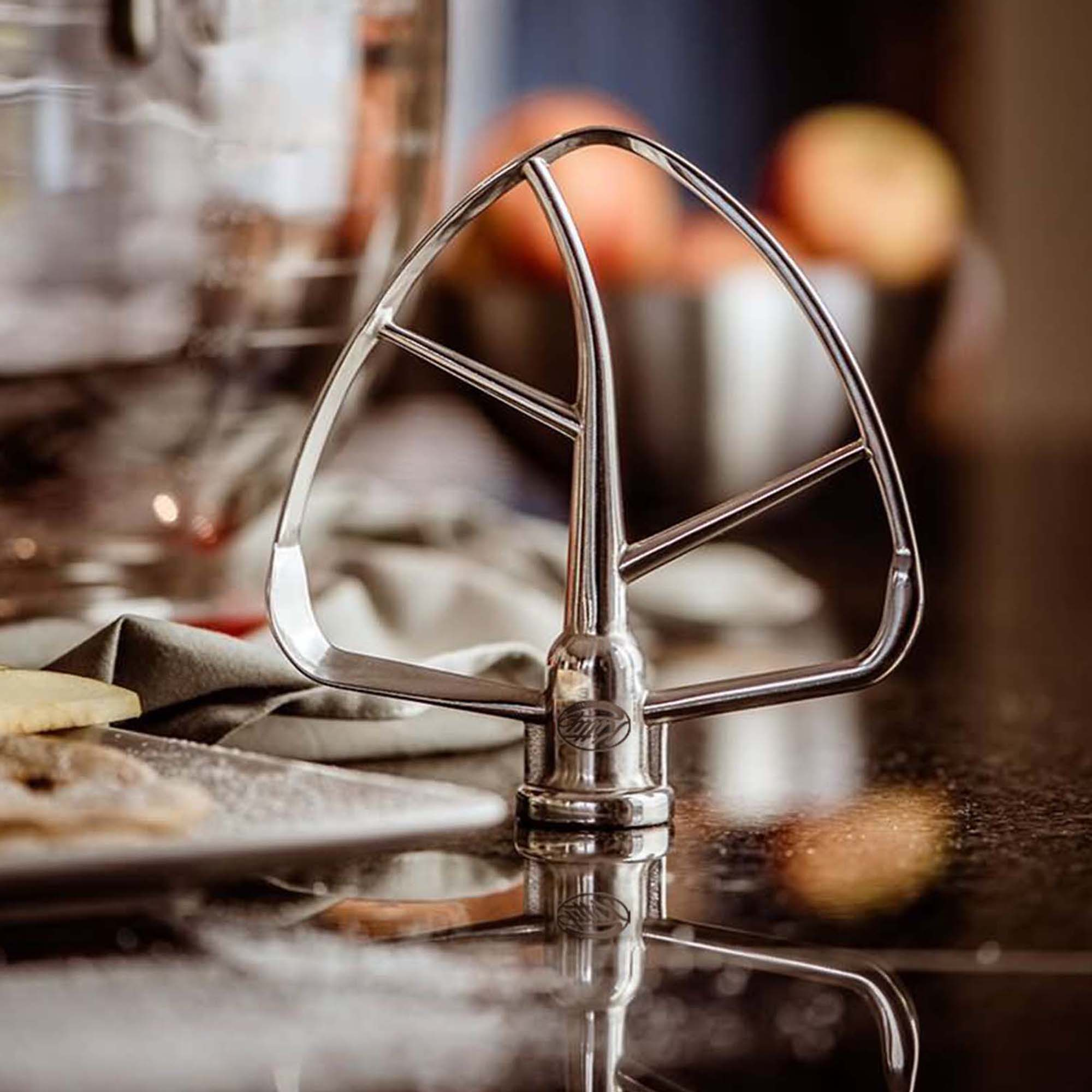 Nahaufnahme eines Mixers, Edelstahl, reflektiert auf dunkler Oberfläche.
