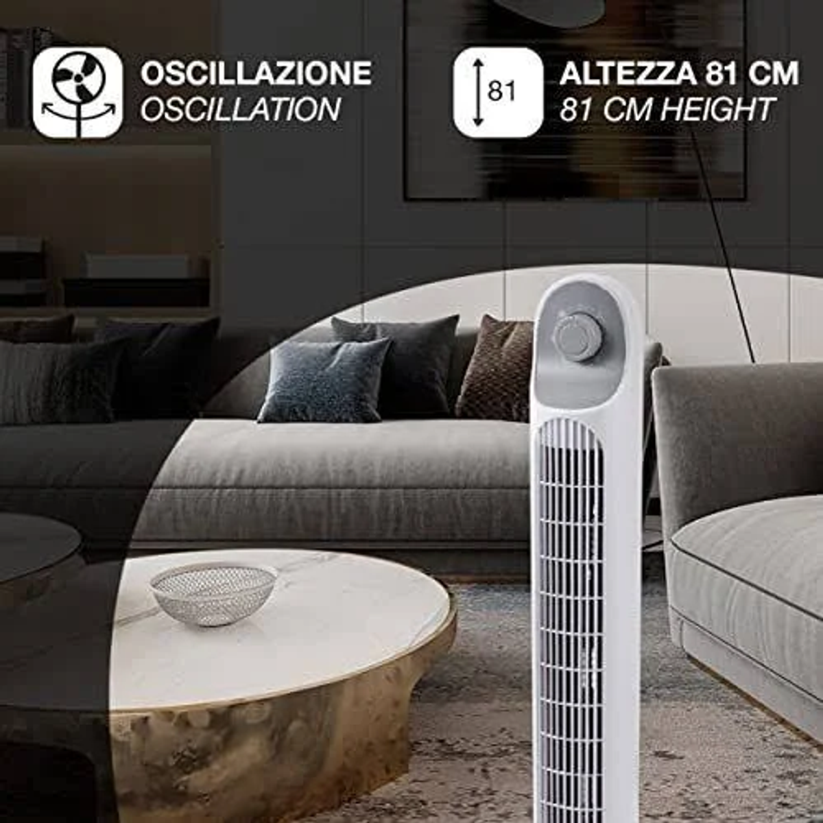 A white tower fan in a modern living room. It is next to a sofa and a coffee table.