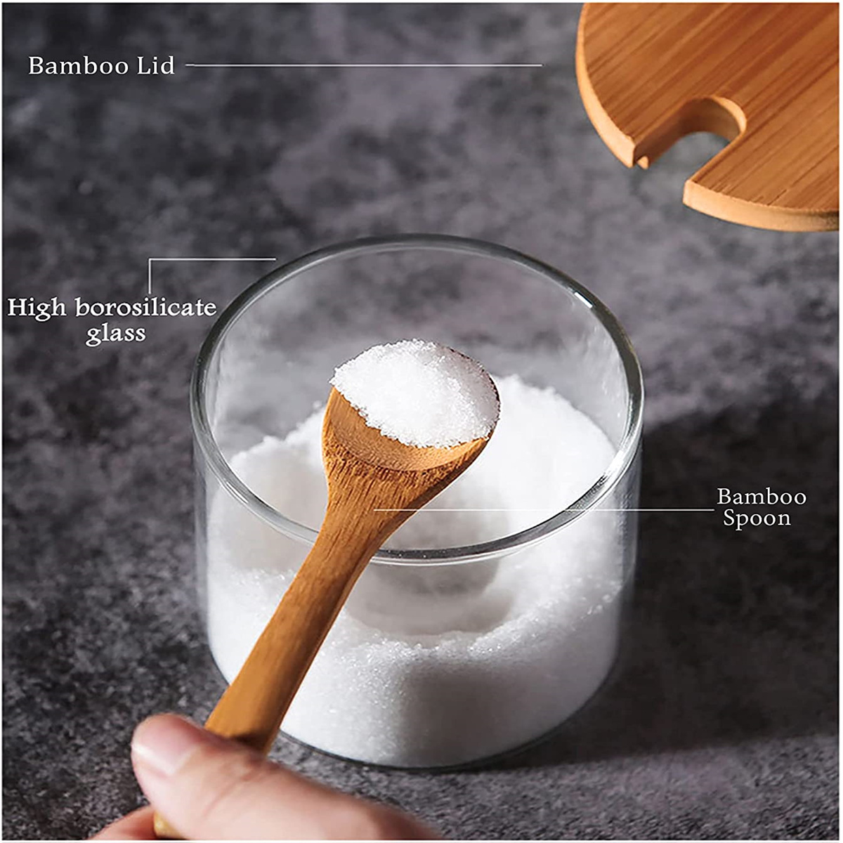 Ein Glas mit weißem Pulver und einem Holzlöffel. Ein Holzdeckel oben drauf. Grauer Hintergrund.