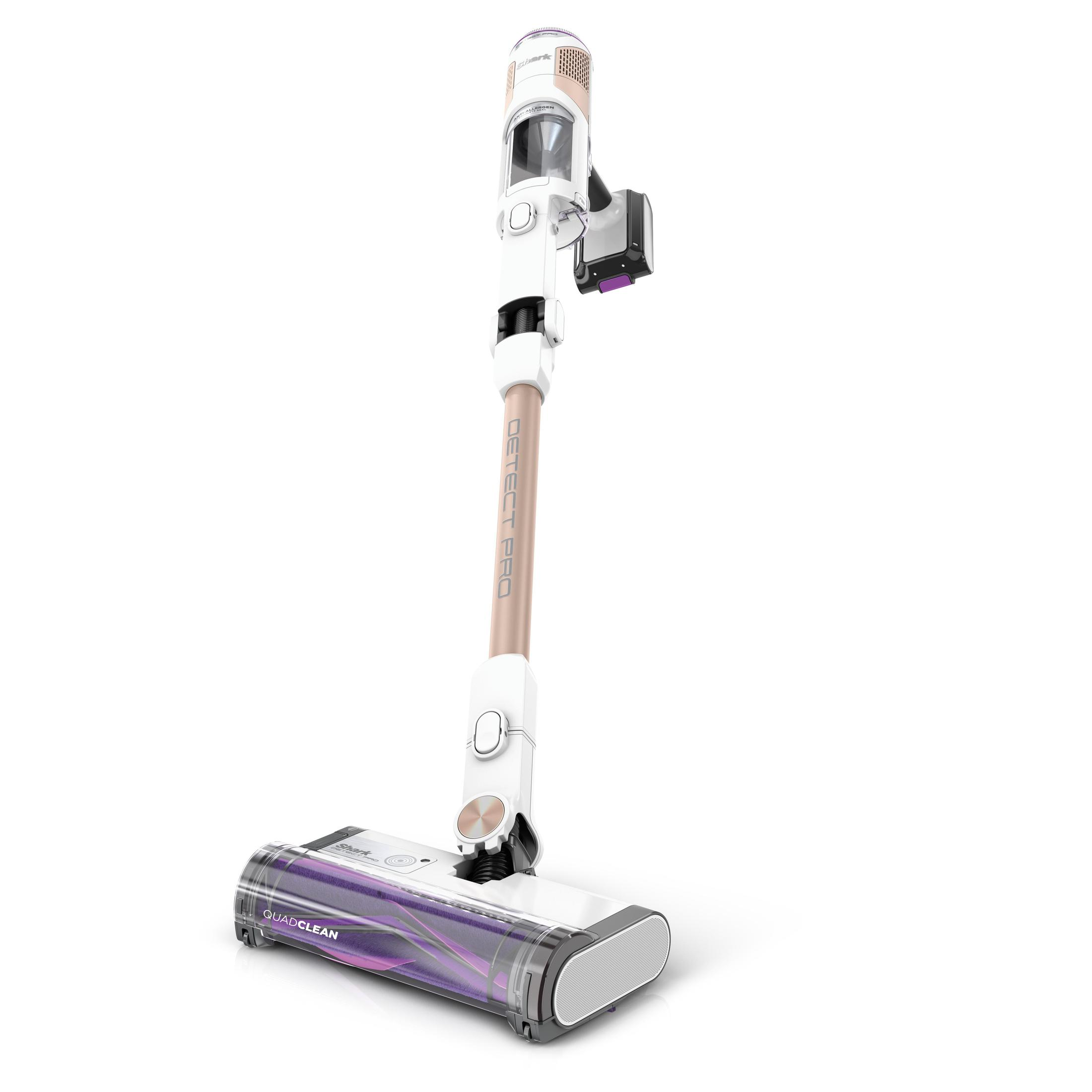 A white and gold cordless vacuum cleaner with a brush head on the floor. It's angled slightly.