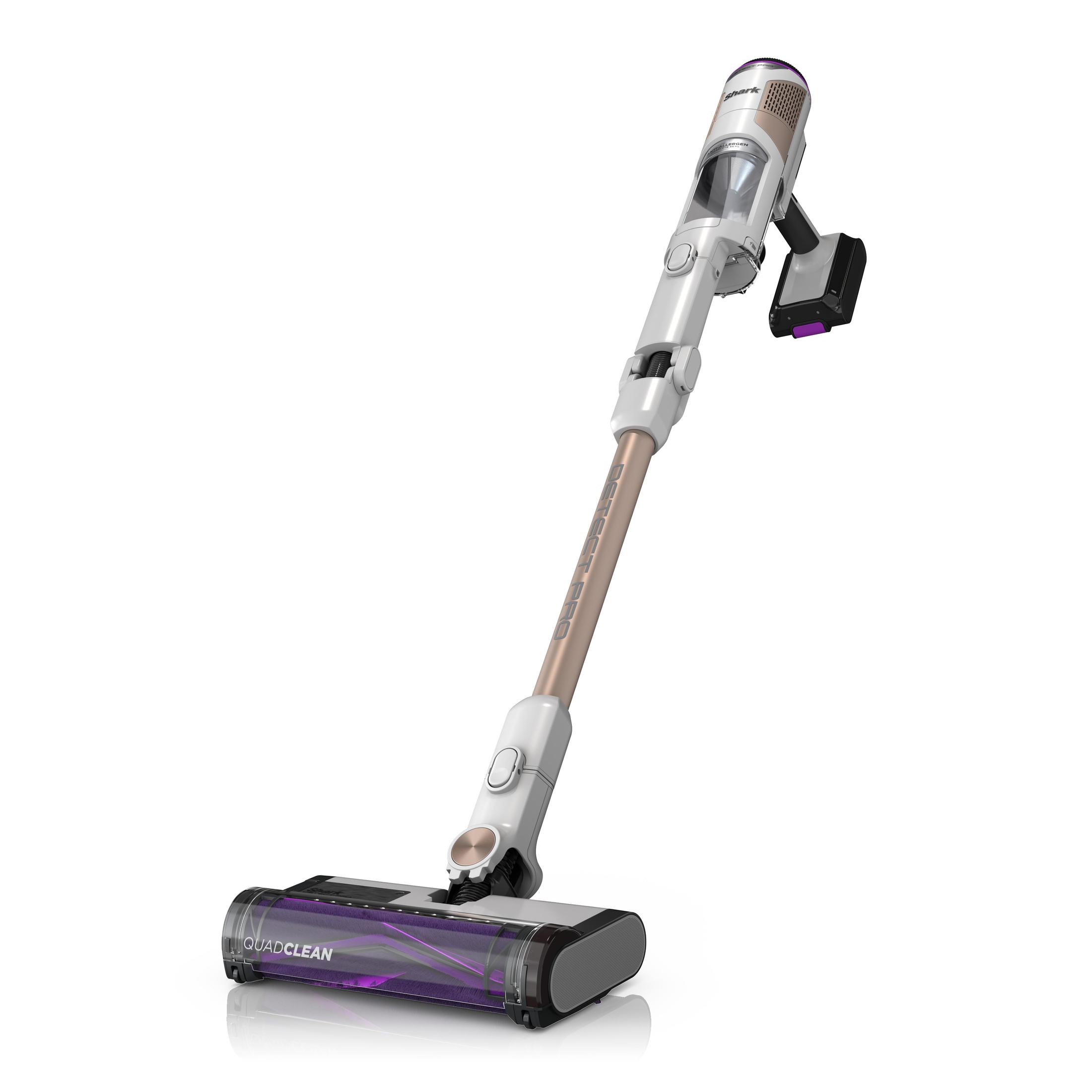 White and gold cordless vacuum cleaner. It has a main body, a long handle and a brush head.