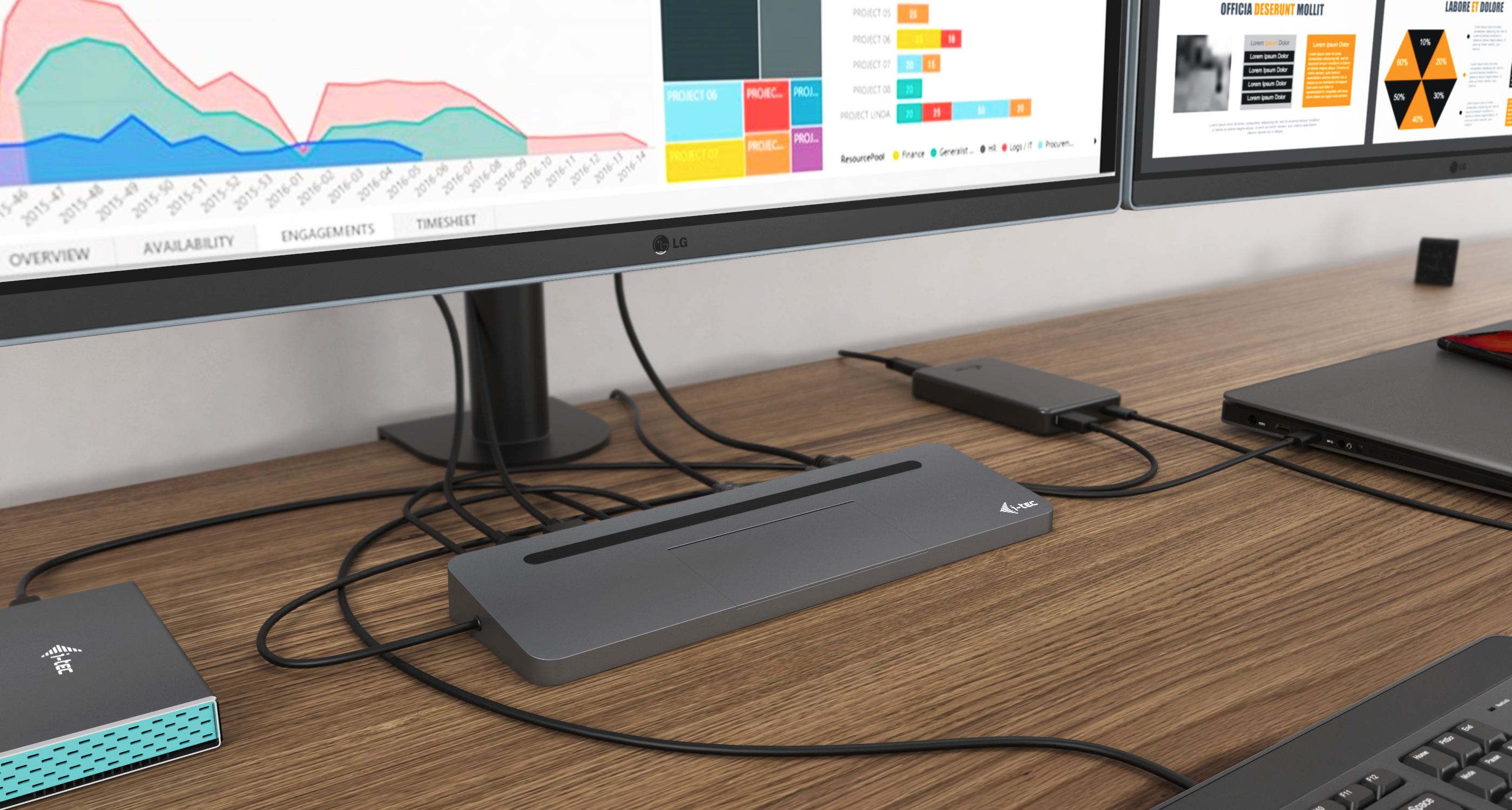 Een bureau-opstelling met meerdere monitoren, een laptop en een docking station met diverse aangesloten kabels.