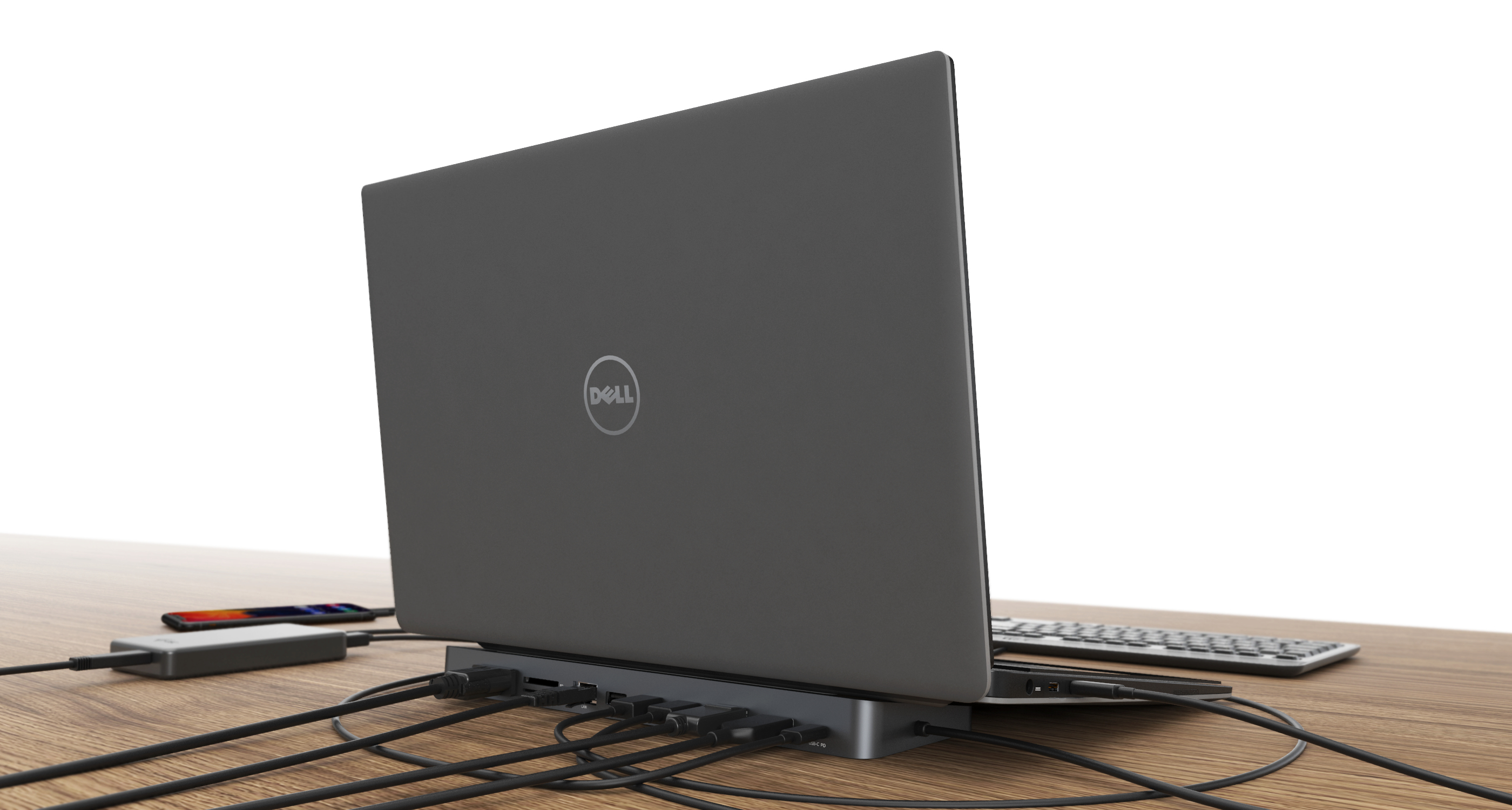 Laptop aangesloten op een hub met meerdere kabels op een houten bureau.