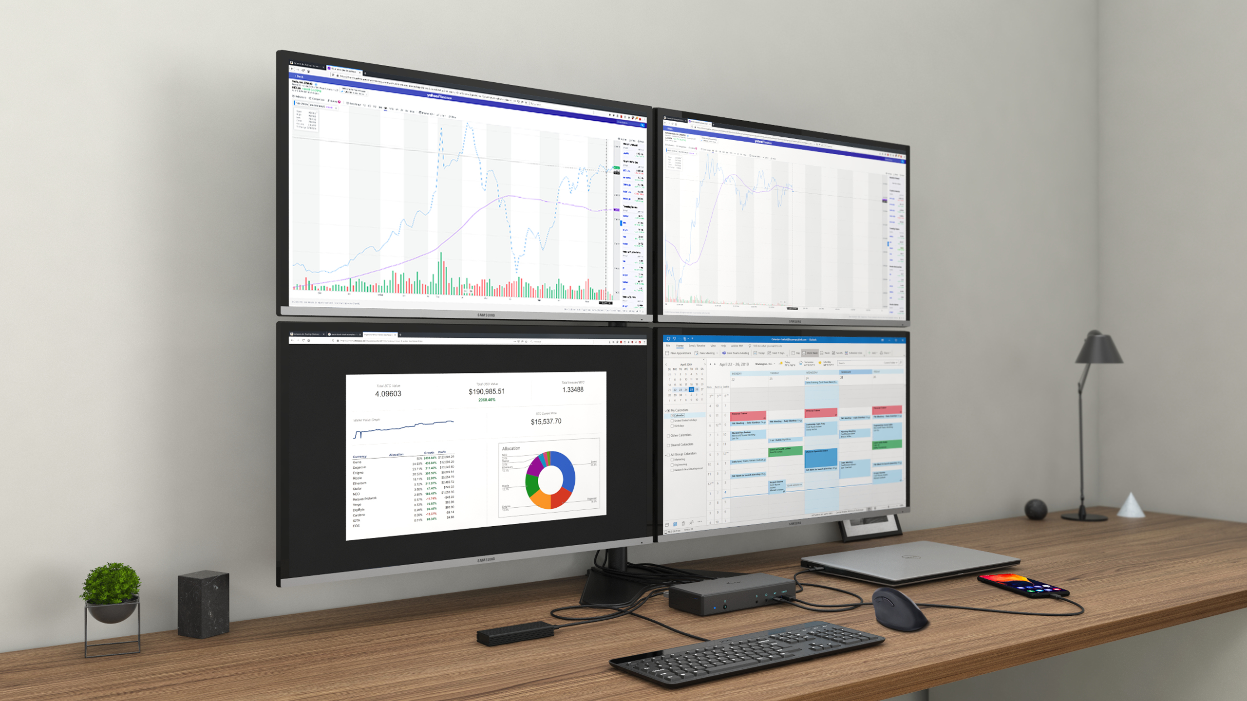 Quattro monitor di computer su una scrivania. Grafici e un calendario sono visualizzati sugli schermi.
