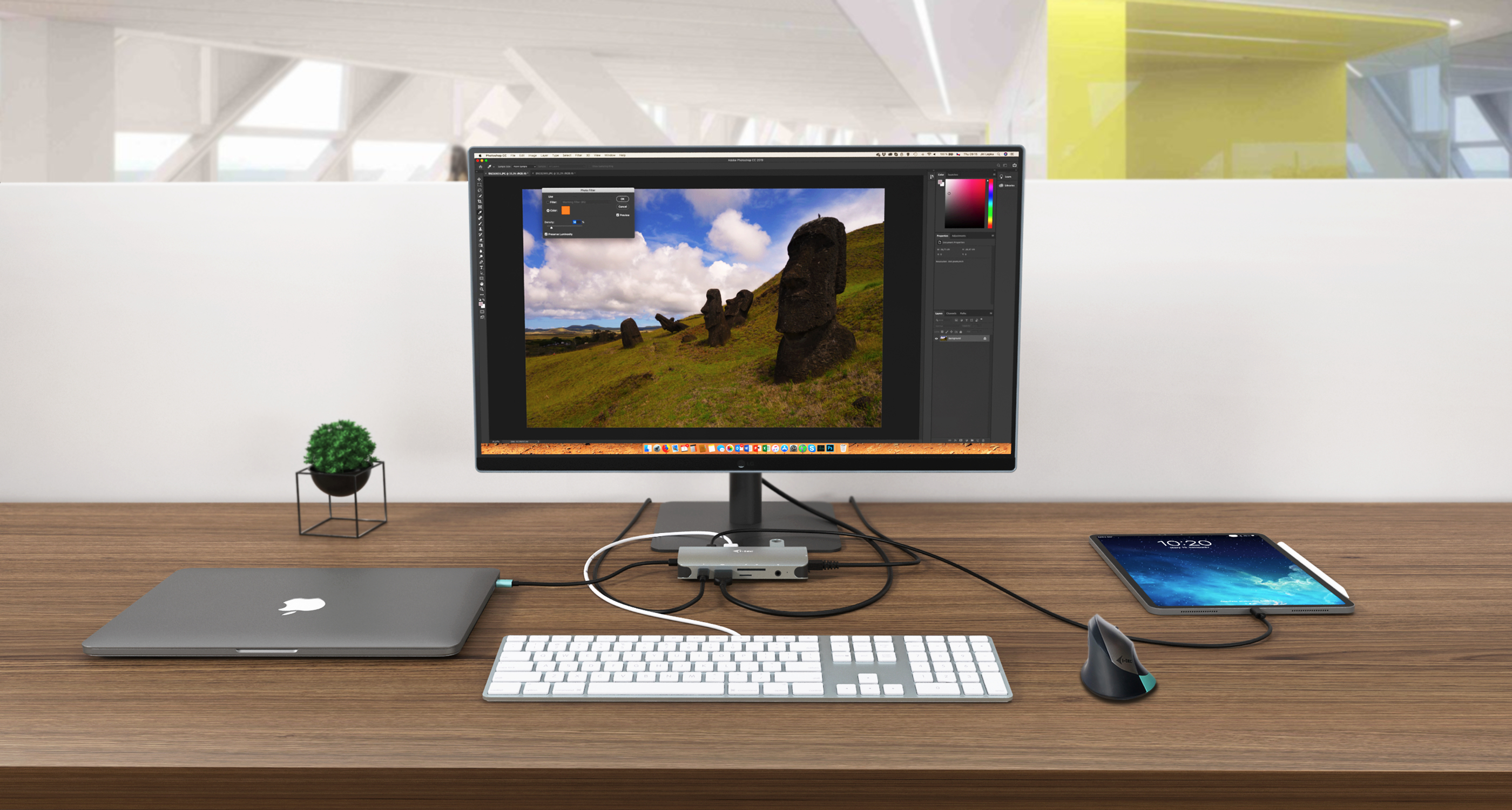 Ein Schreibtisch mit Laptop, Monitor mit Bild, Tastatur, Tablet und Maus.