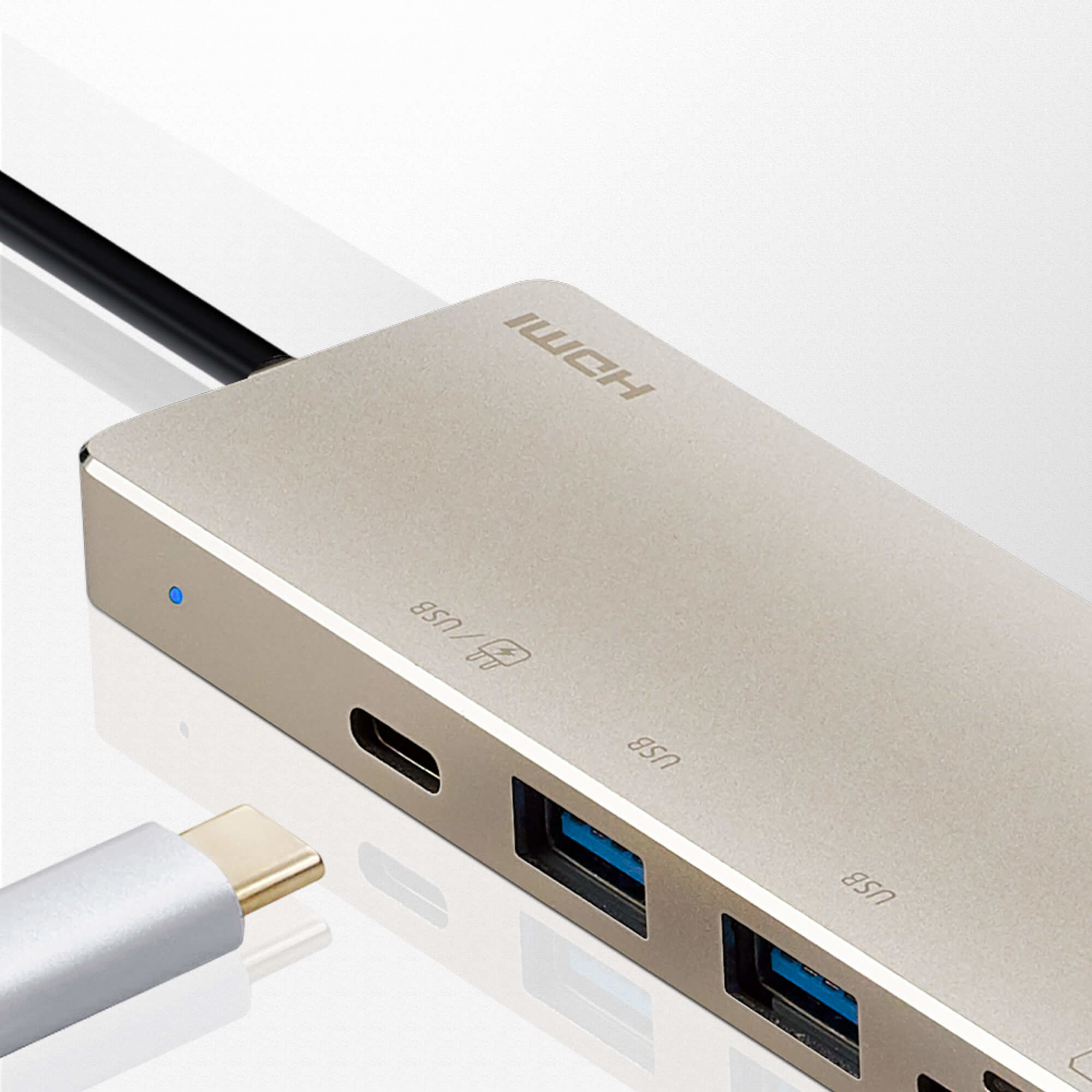 Hub USB argento con più porte e un cavo nero collegato.
